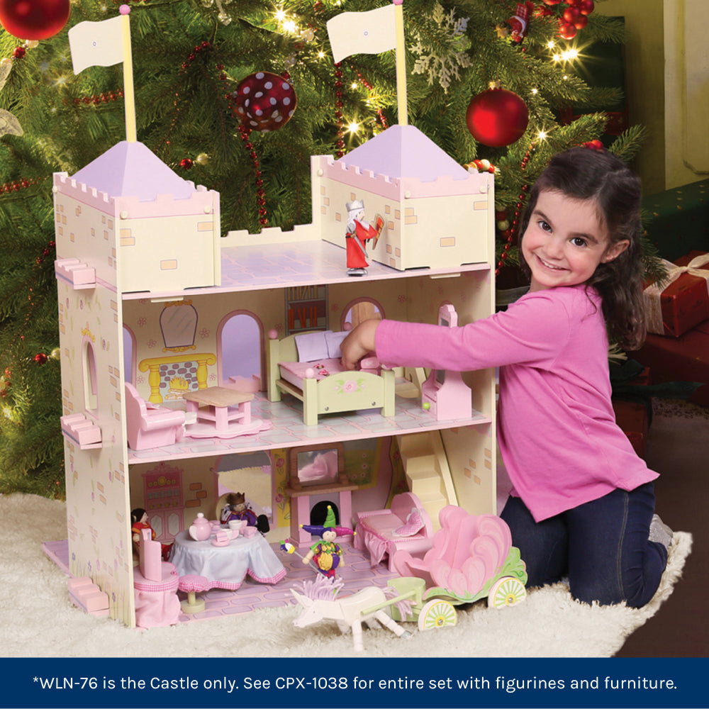 Little Girl Playing with Wooden Fairytale Castle in Front of Christmas Tree