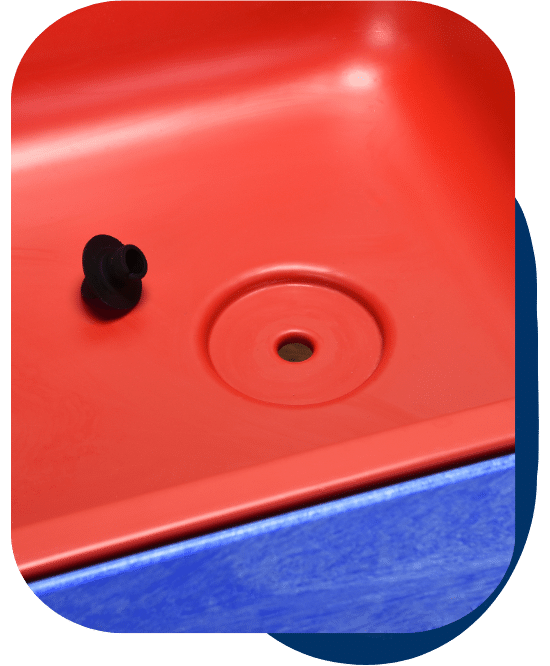 up-close detail of the drain at the bottom of the sand and water table with the rubber plug removed from the drainage hole