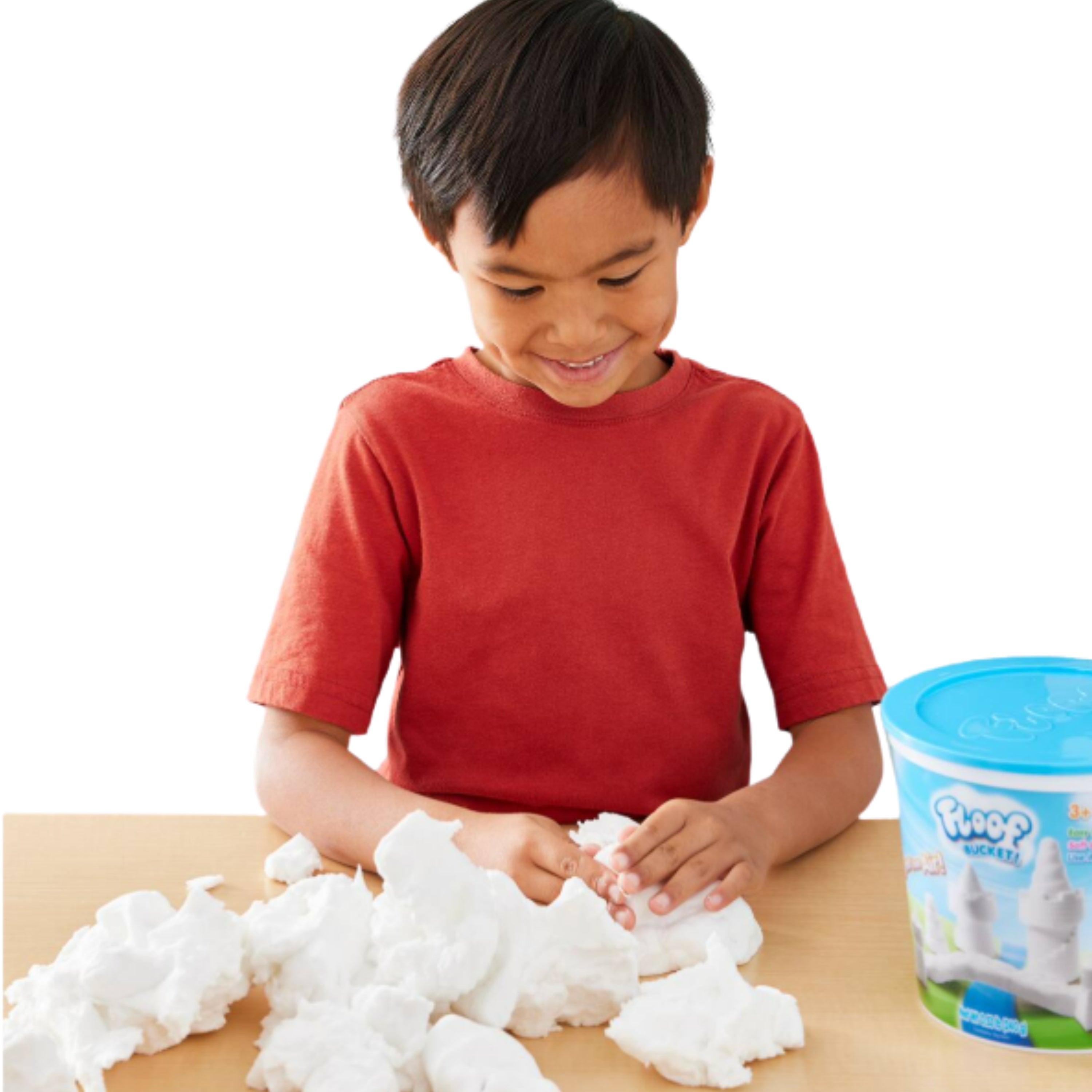 Child playing with Floof on a table with a container in the background.