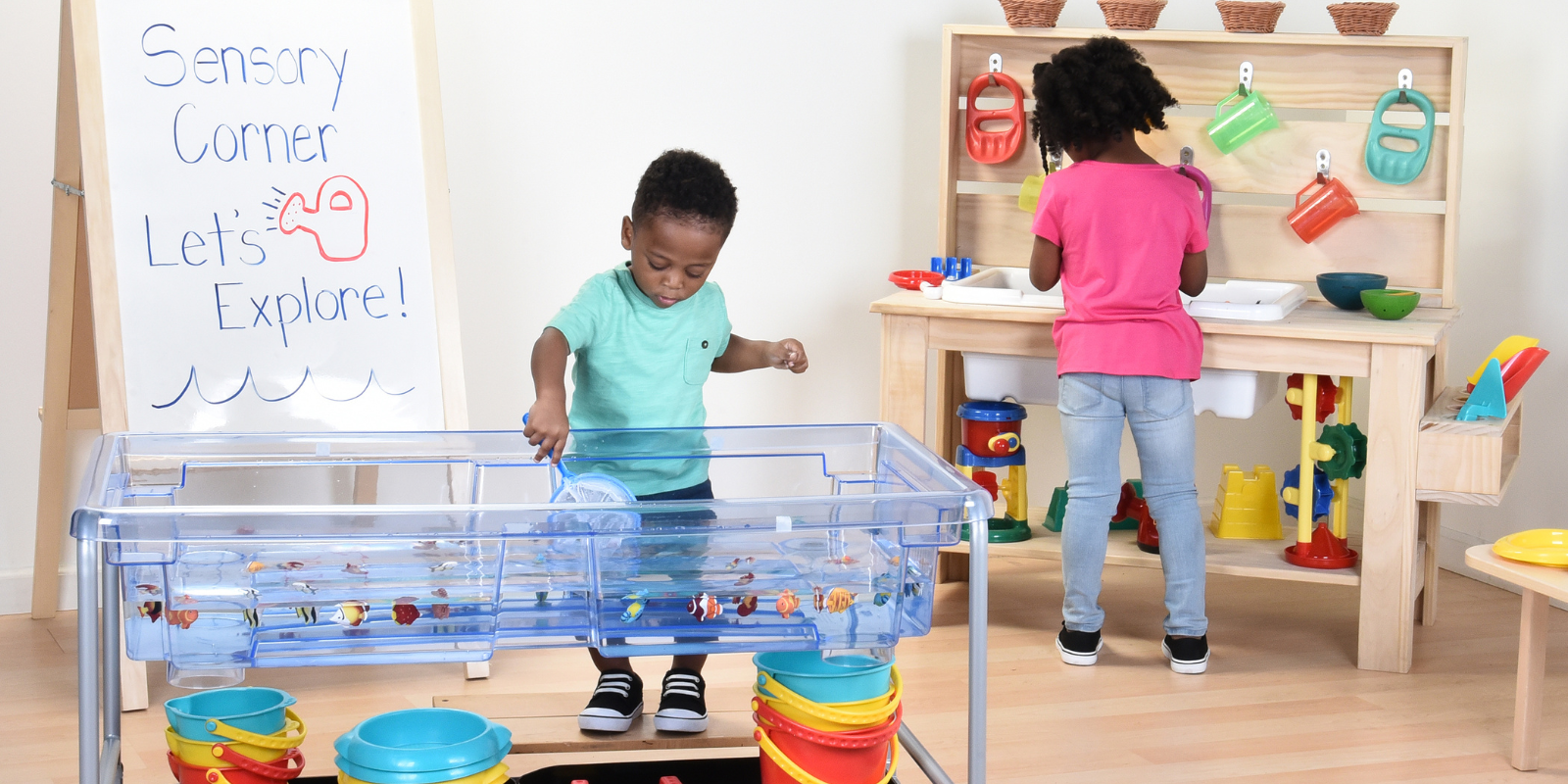 Children playing with sensory tables in a classroom setting