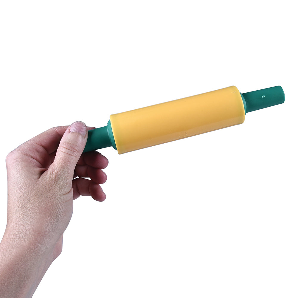 Hand holding a yellow rolling pin with green handles on a white background