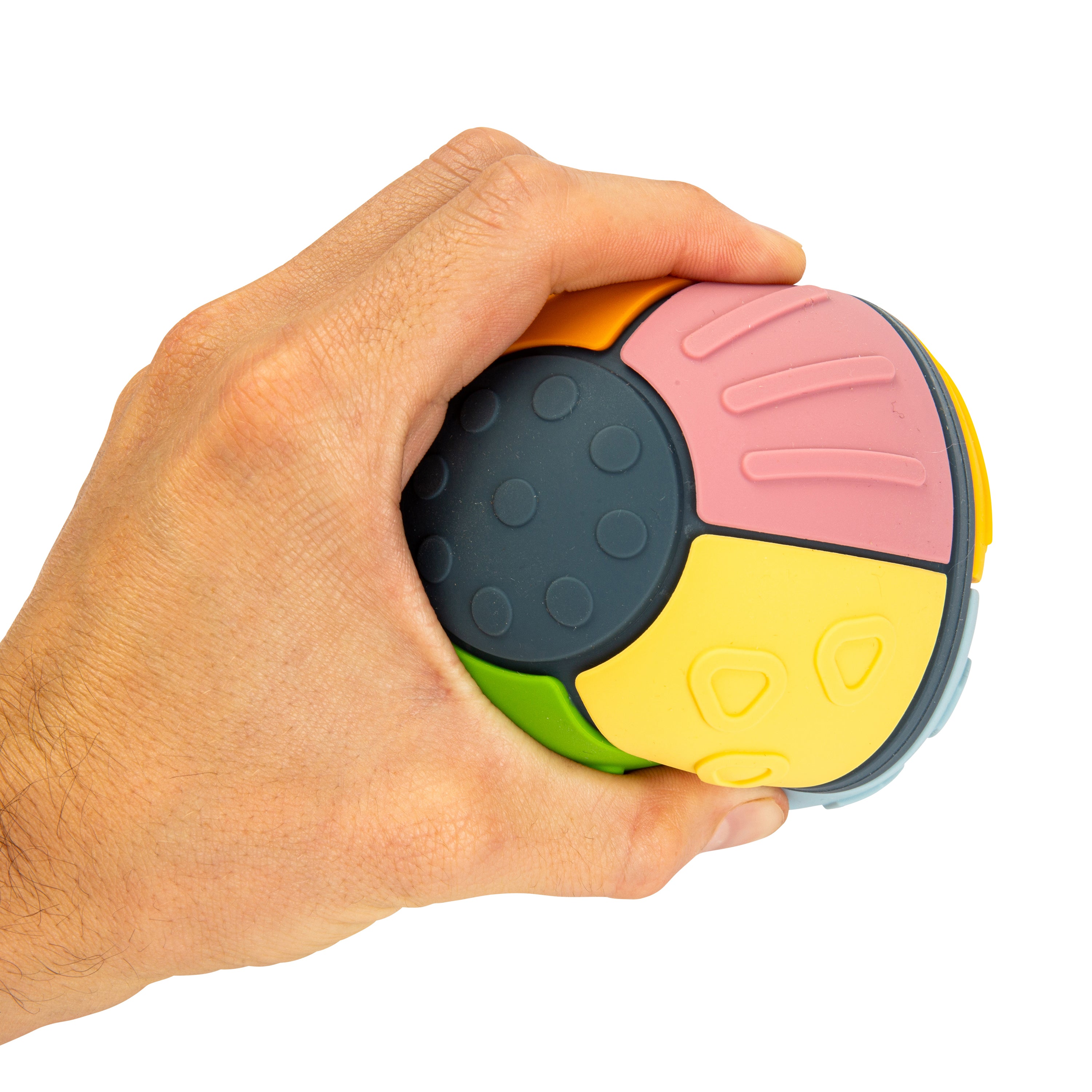 A hand holding a colorful textured sensory ball toy against a plain white background.