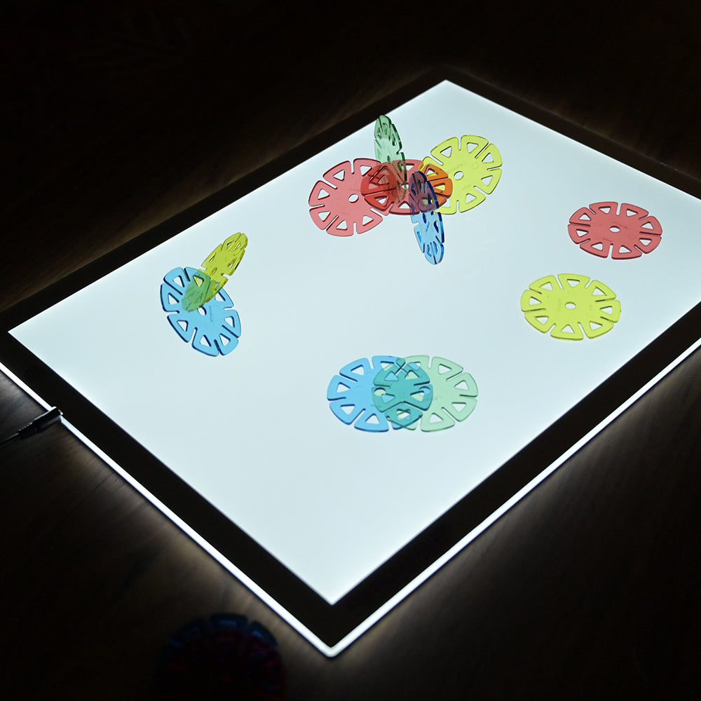 Colorful discs on a light table with dark background