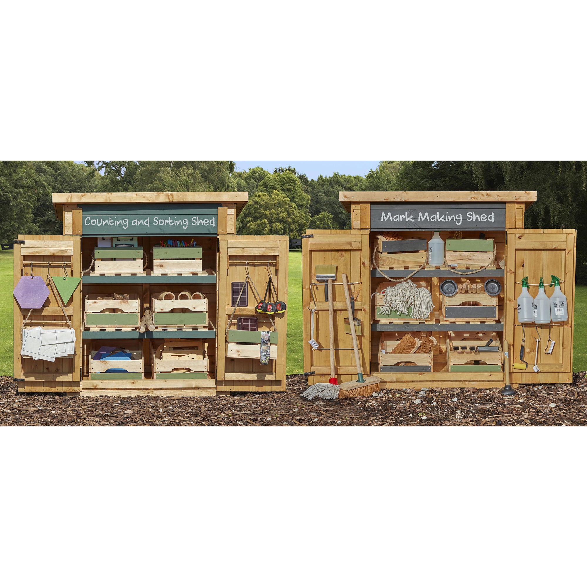 Wooden playsets labeled 'Counting and Sorting Shed' and 'Mark Making Shed' with various items on a grassy background.