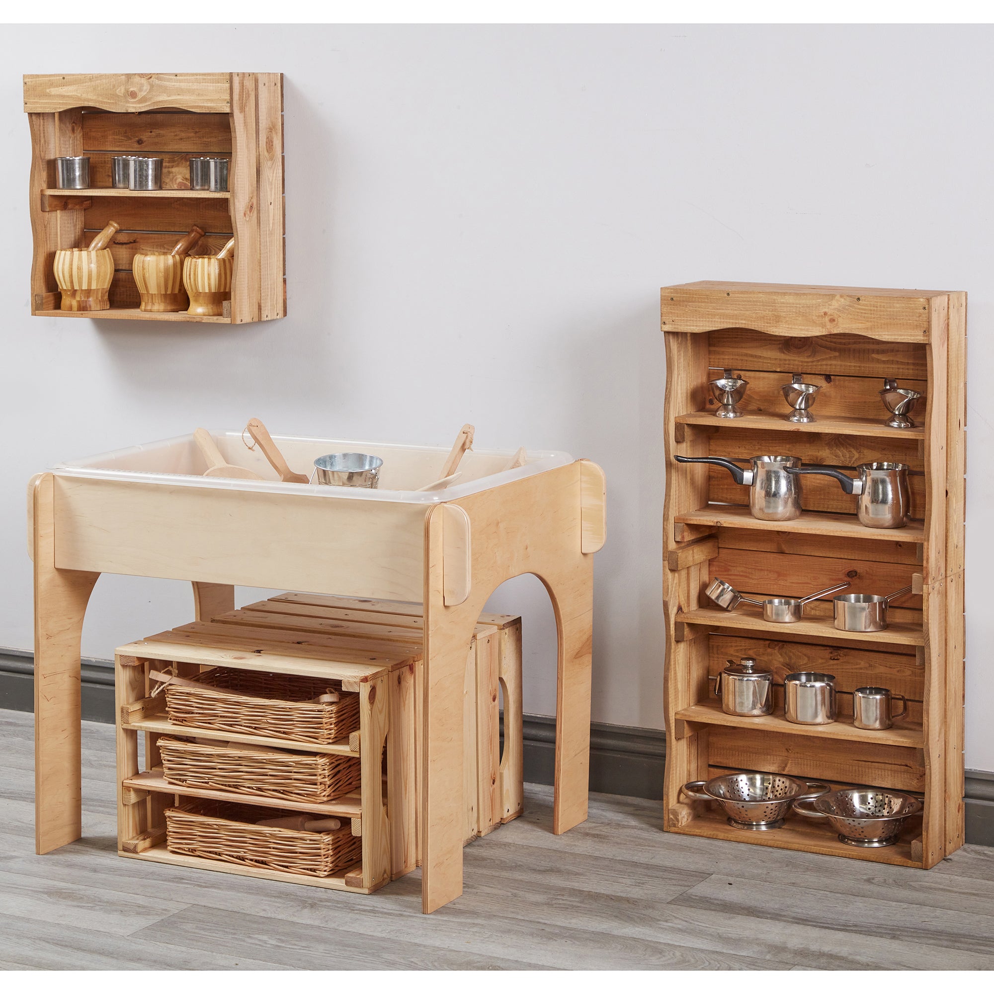 Wooden play kitchen set with shelves and pots on a light gray background