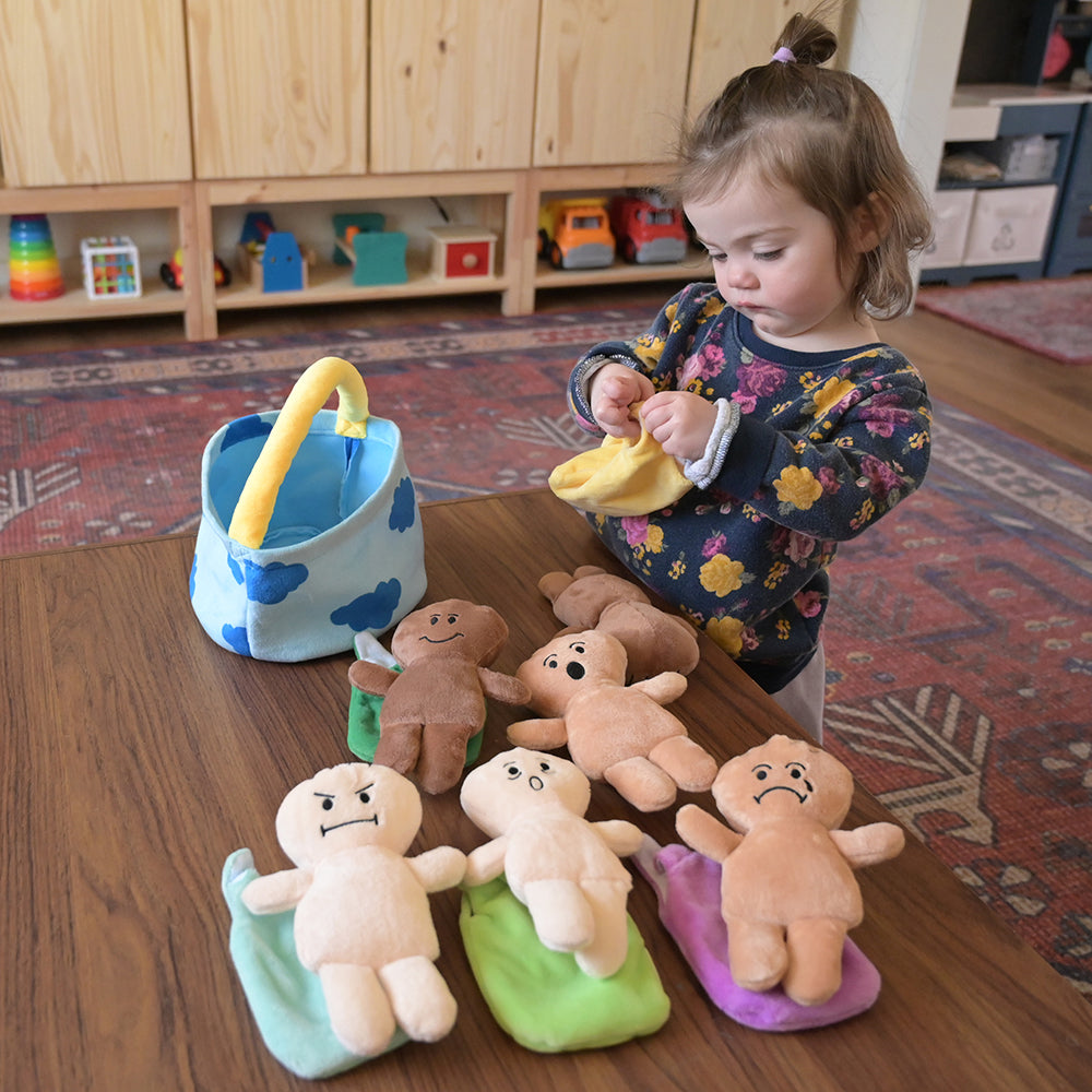 Toddler Playing with Plush Expression Baby Dolls with Removable Sleep Sacks