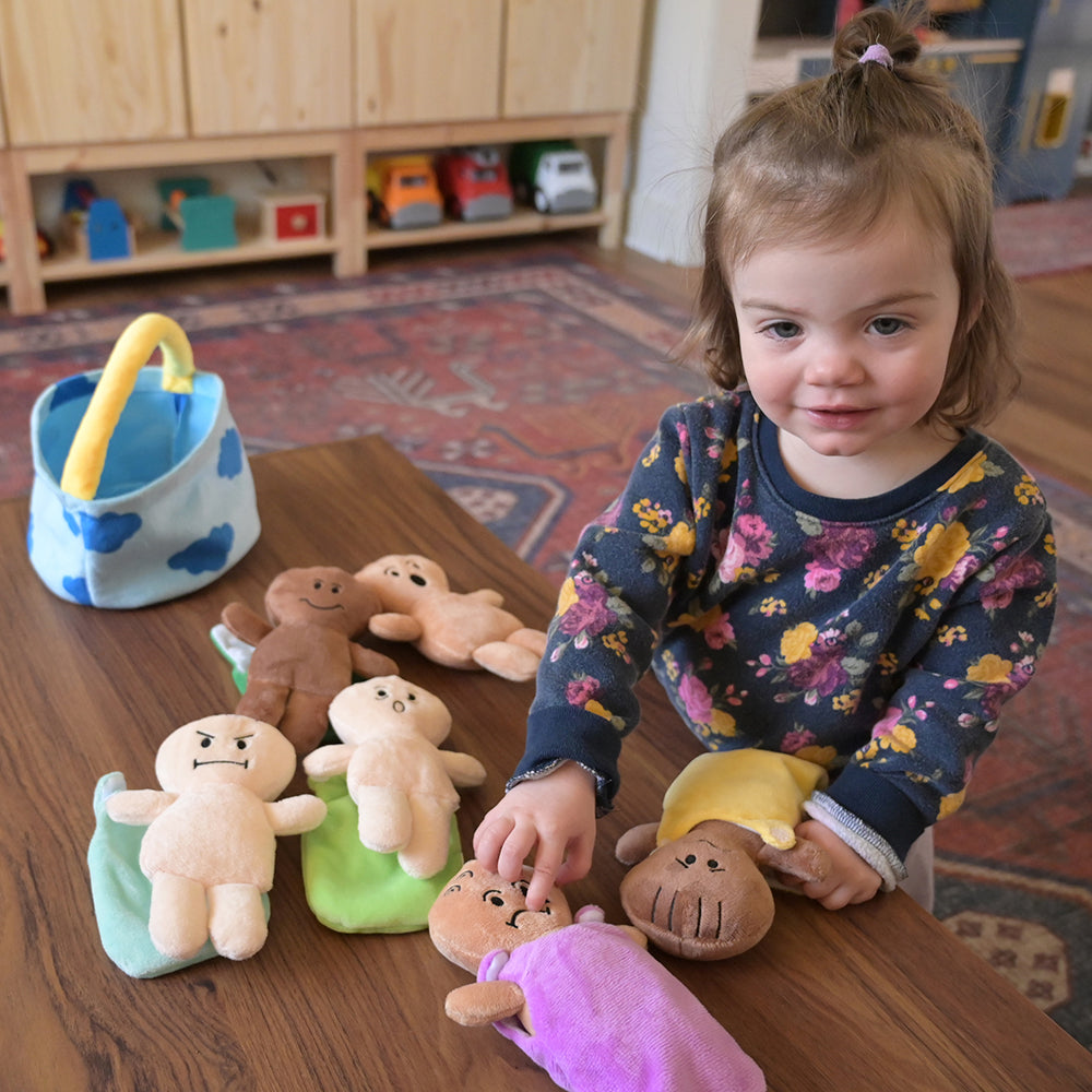 Toddler Playing with Diverse Plush Expression Baby Dolls with Removable Sleep Sacks