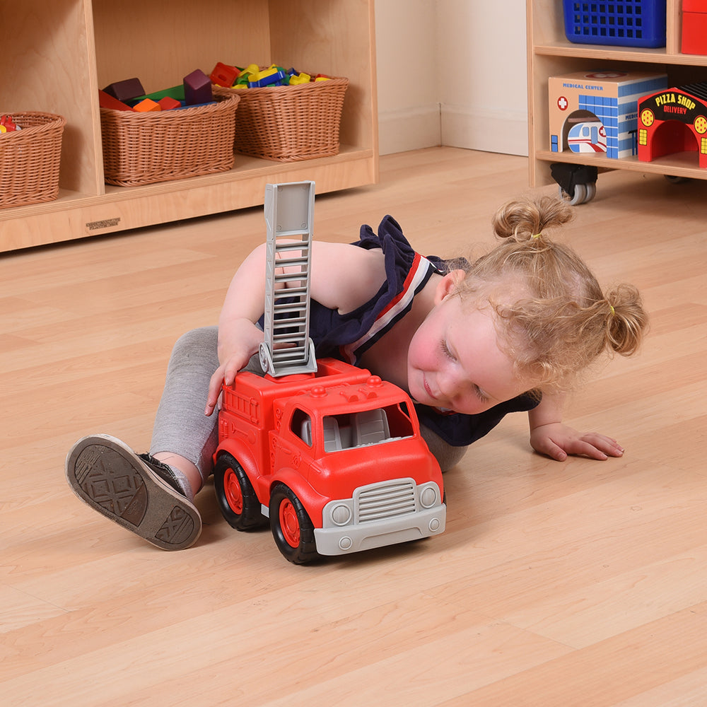 Toddler in Classroom Engaging with Toy Firefighter Truck