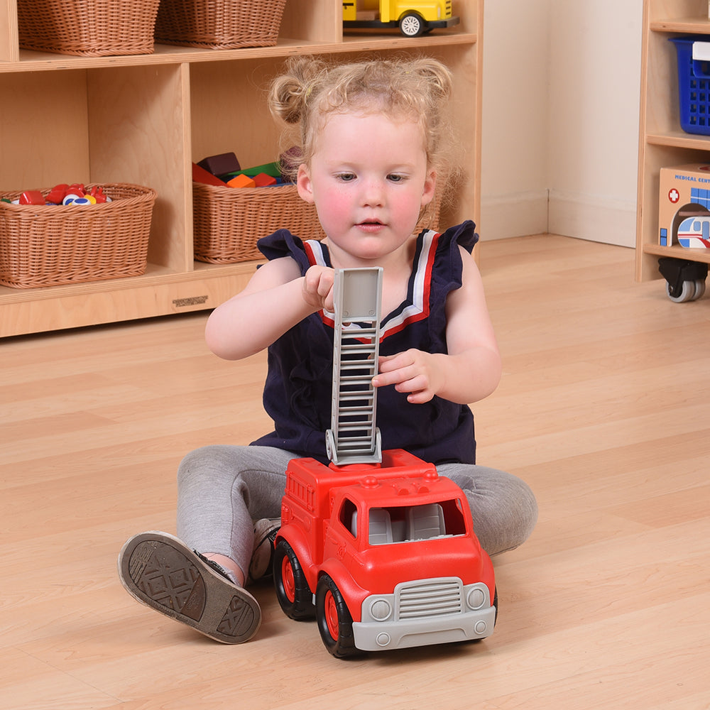 Toddler in Classroom Engaging with Toy Firefighter Truck