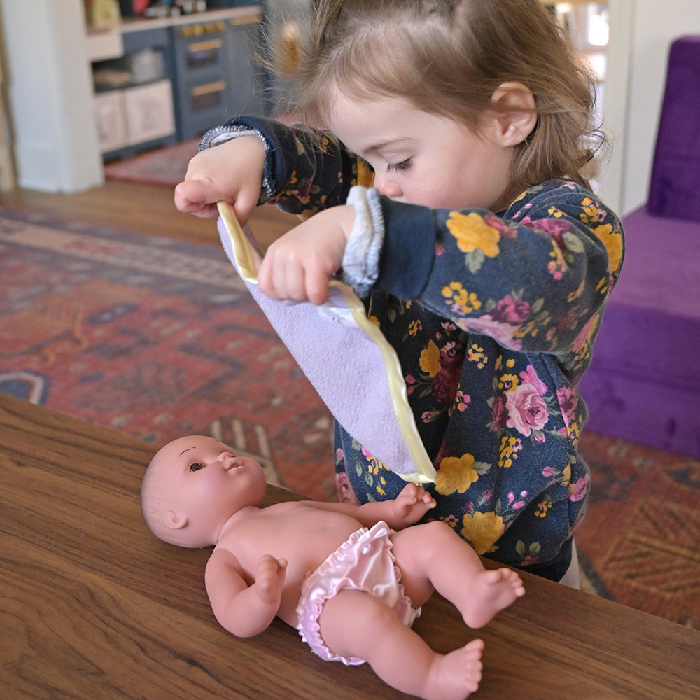Toddler Covering Baby Doll with Blanket