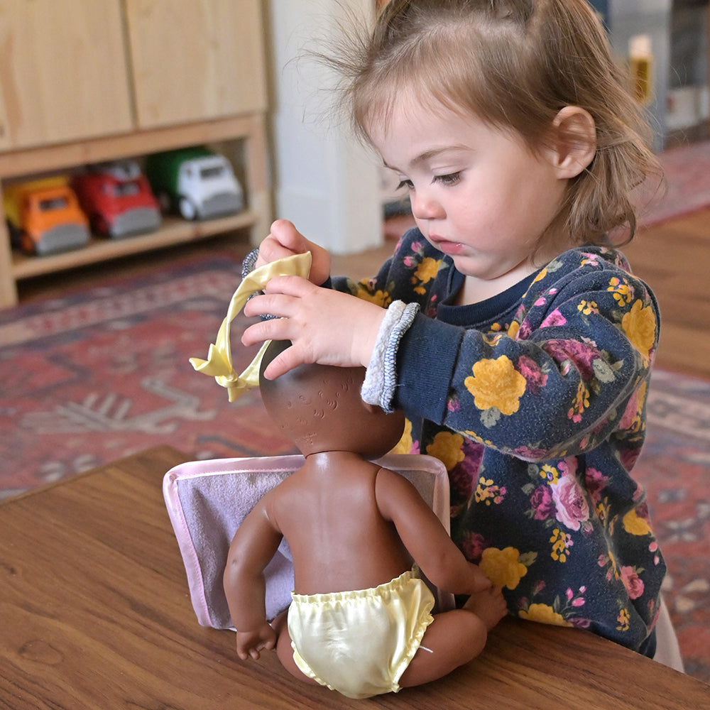 Toddler Adding Head Piece to Baby Doll
