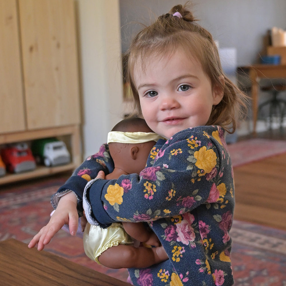 Toddler Cuddling a Baby Doll
