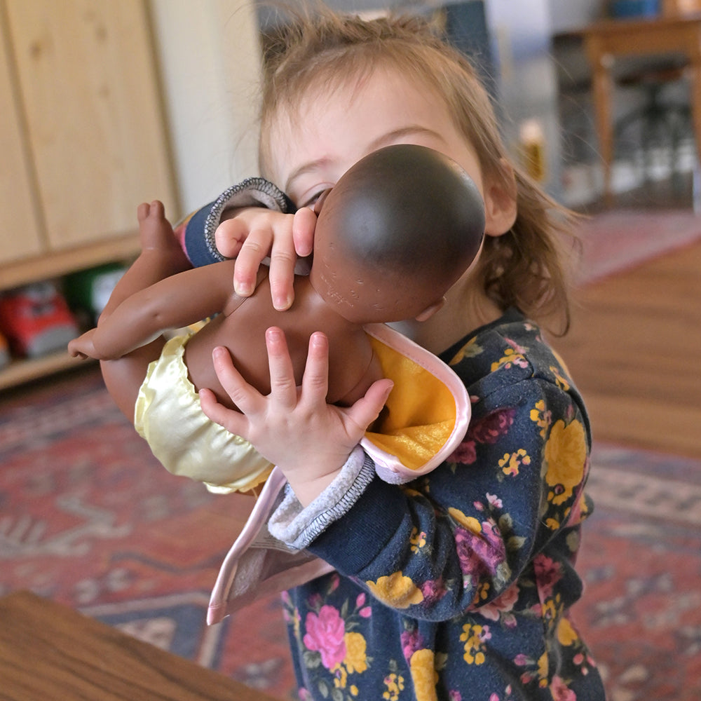 Toddler Giving Baby Doll A Kiss