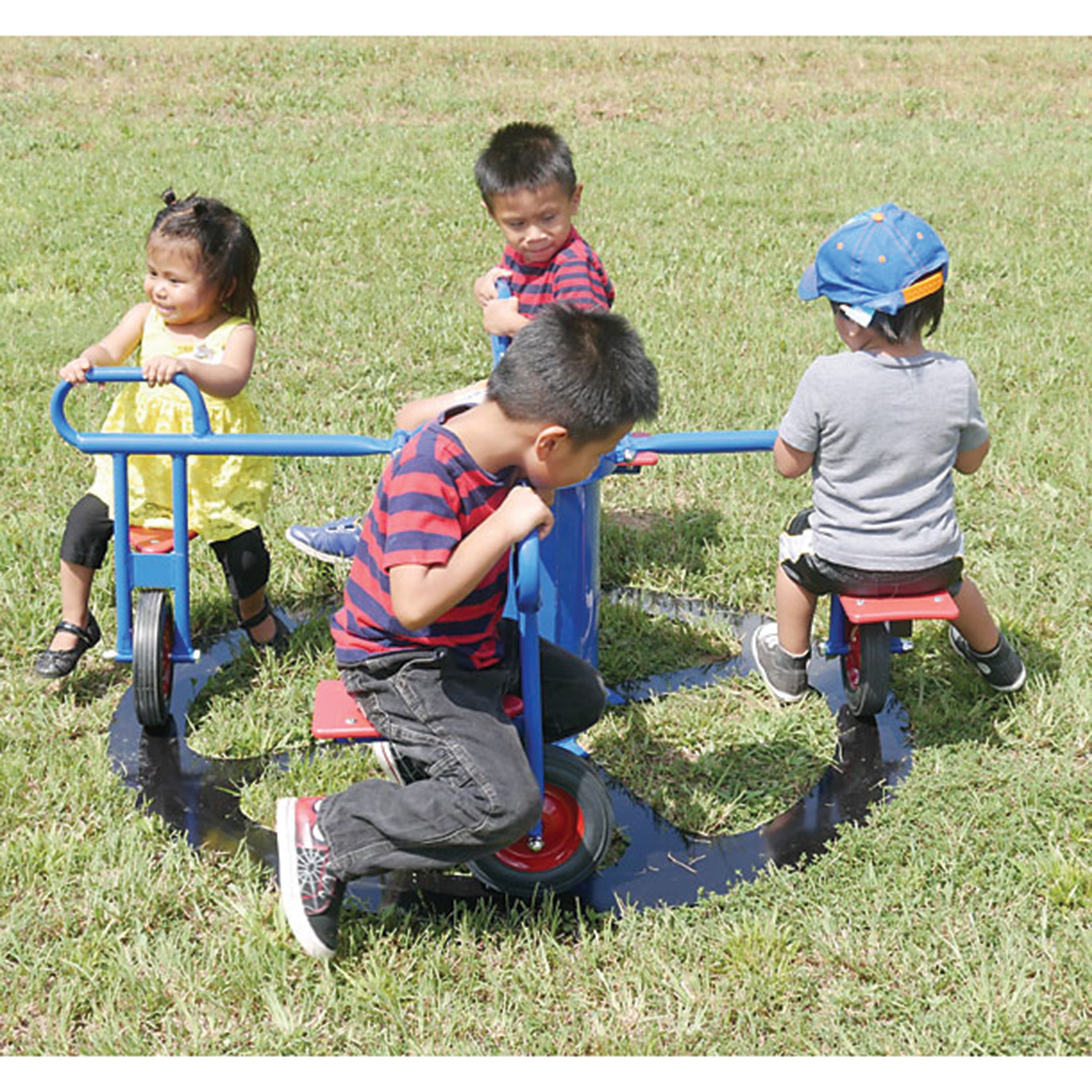 Children playing on trikes in a grassy area