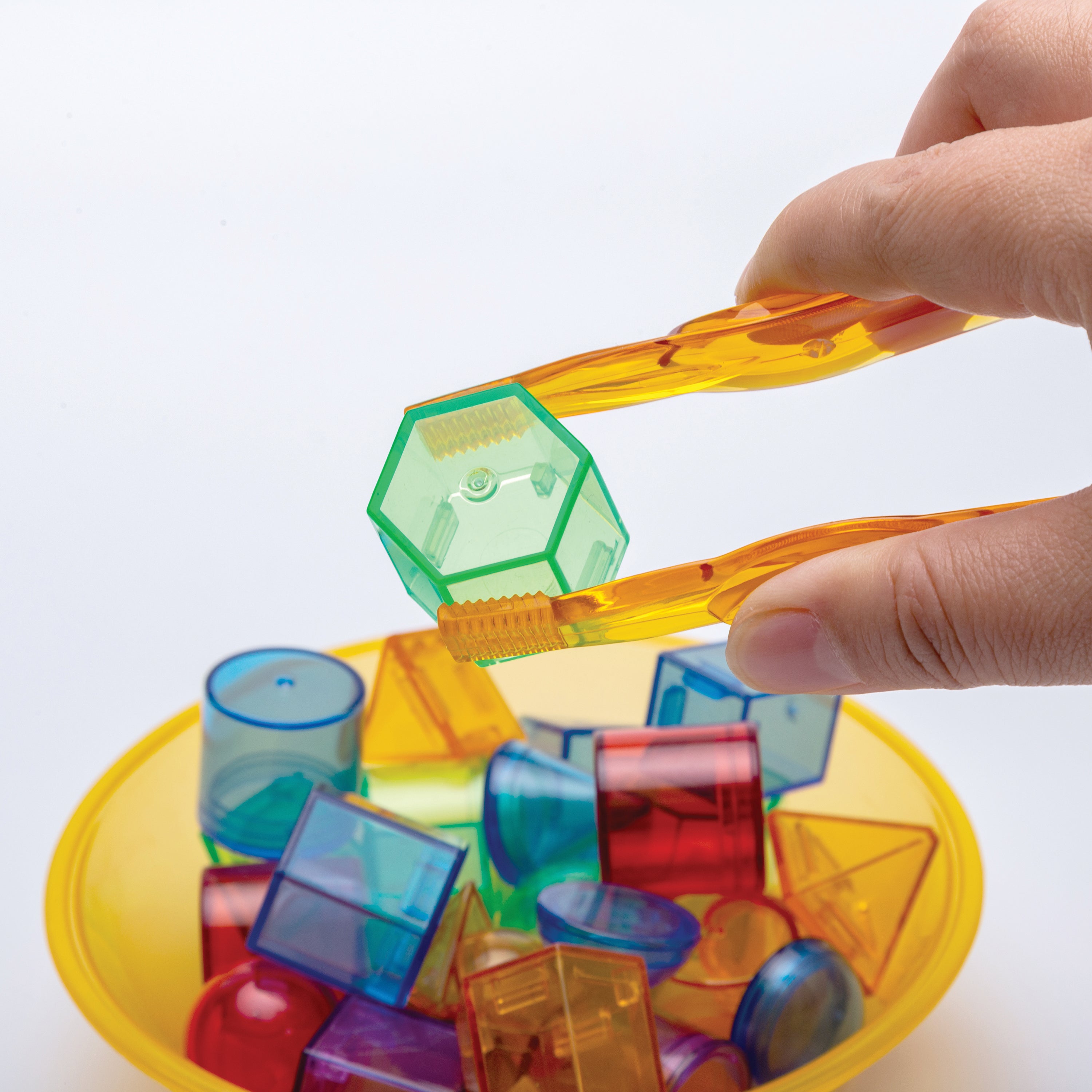 Hand interacting with colorful transparent geometric shapes on a white background