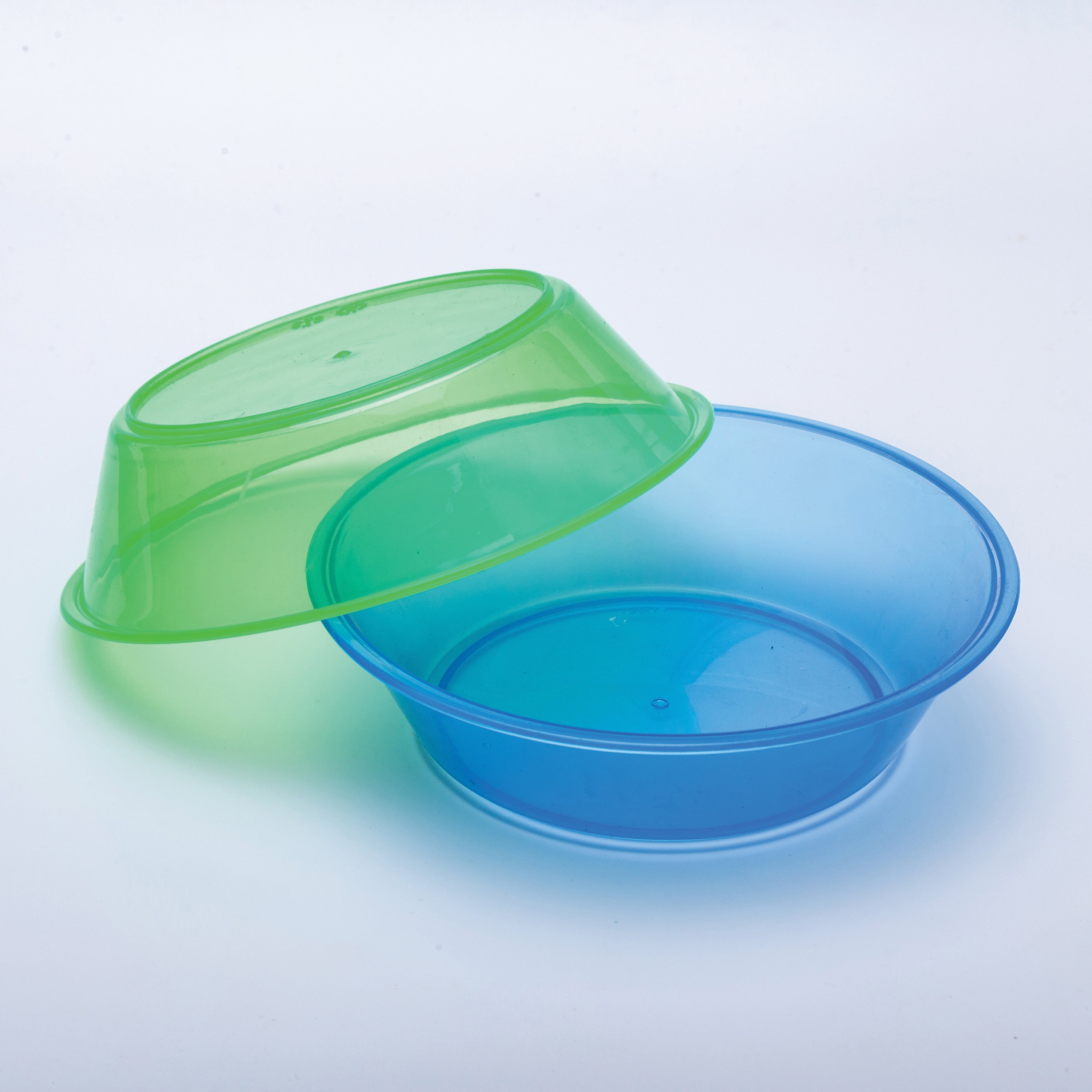 Blue plastic bowl with a green plastic bowl on a light gray background