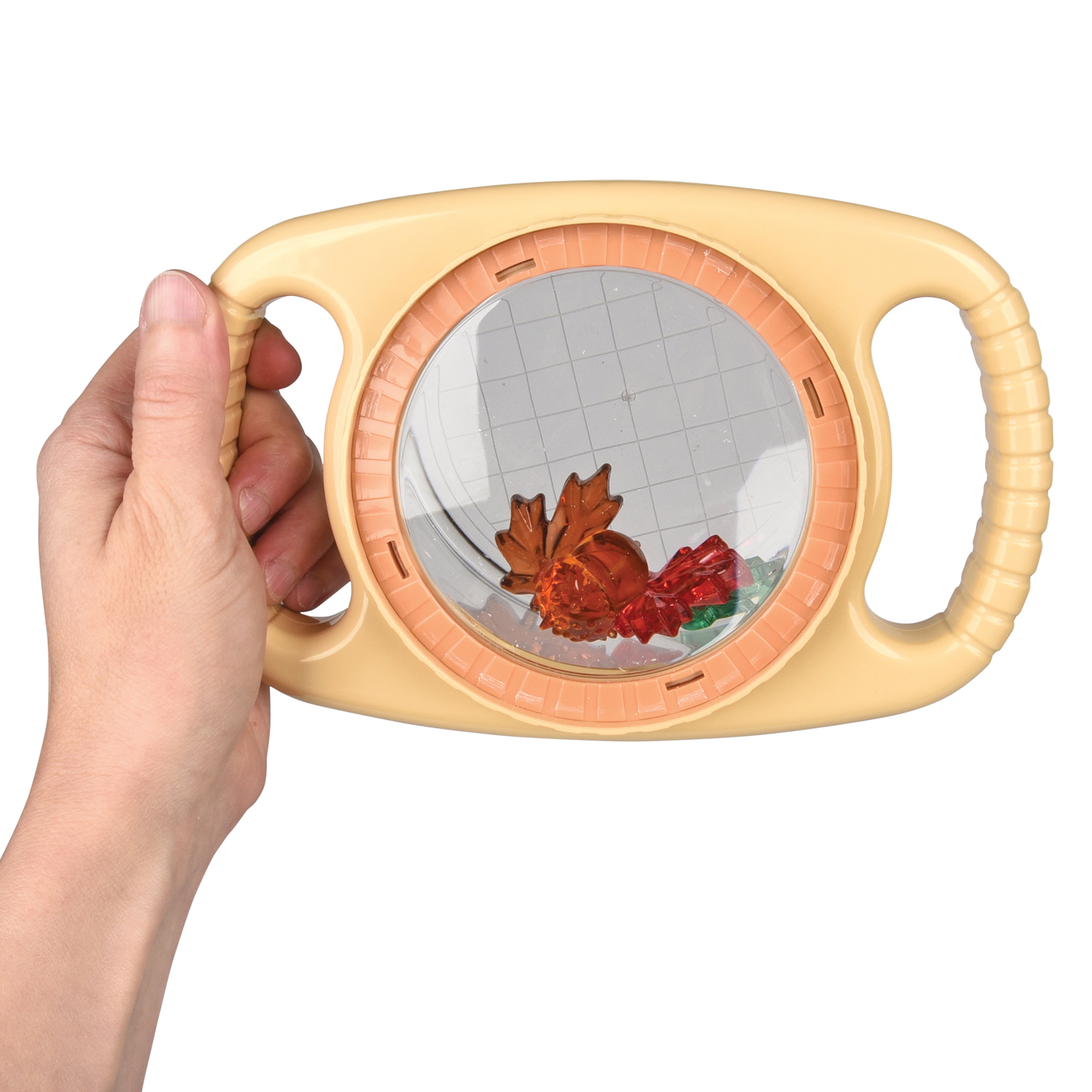Hand holding a round magnifier with floral toys on a white background