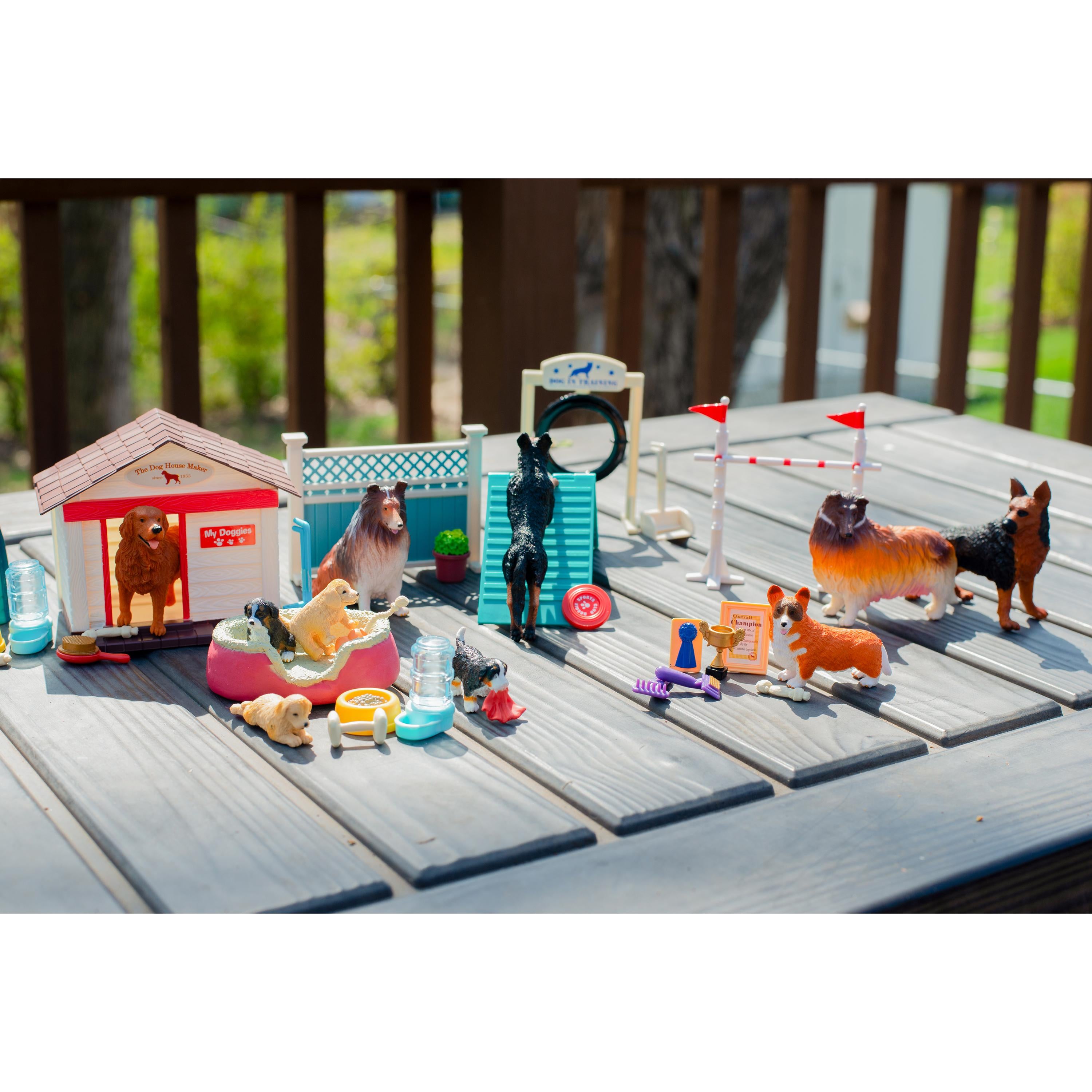 Toy dog grooming station with various dog figurines on a wooden surface.