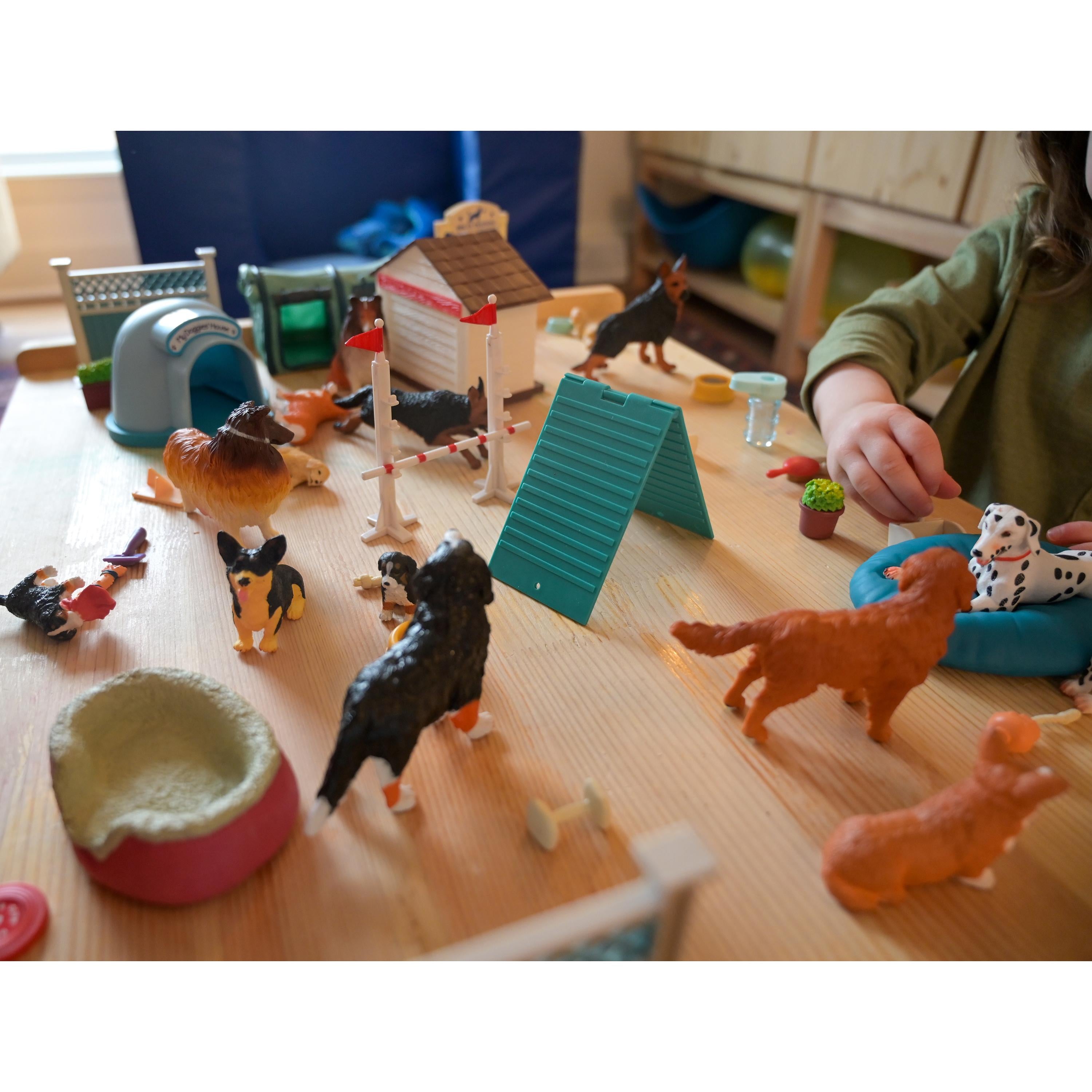 Children's toy set with animal figures and play structures on a wooden surface.