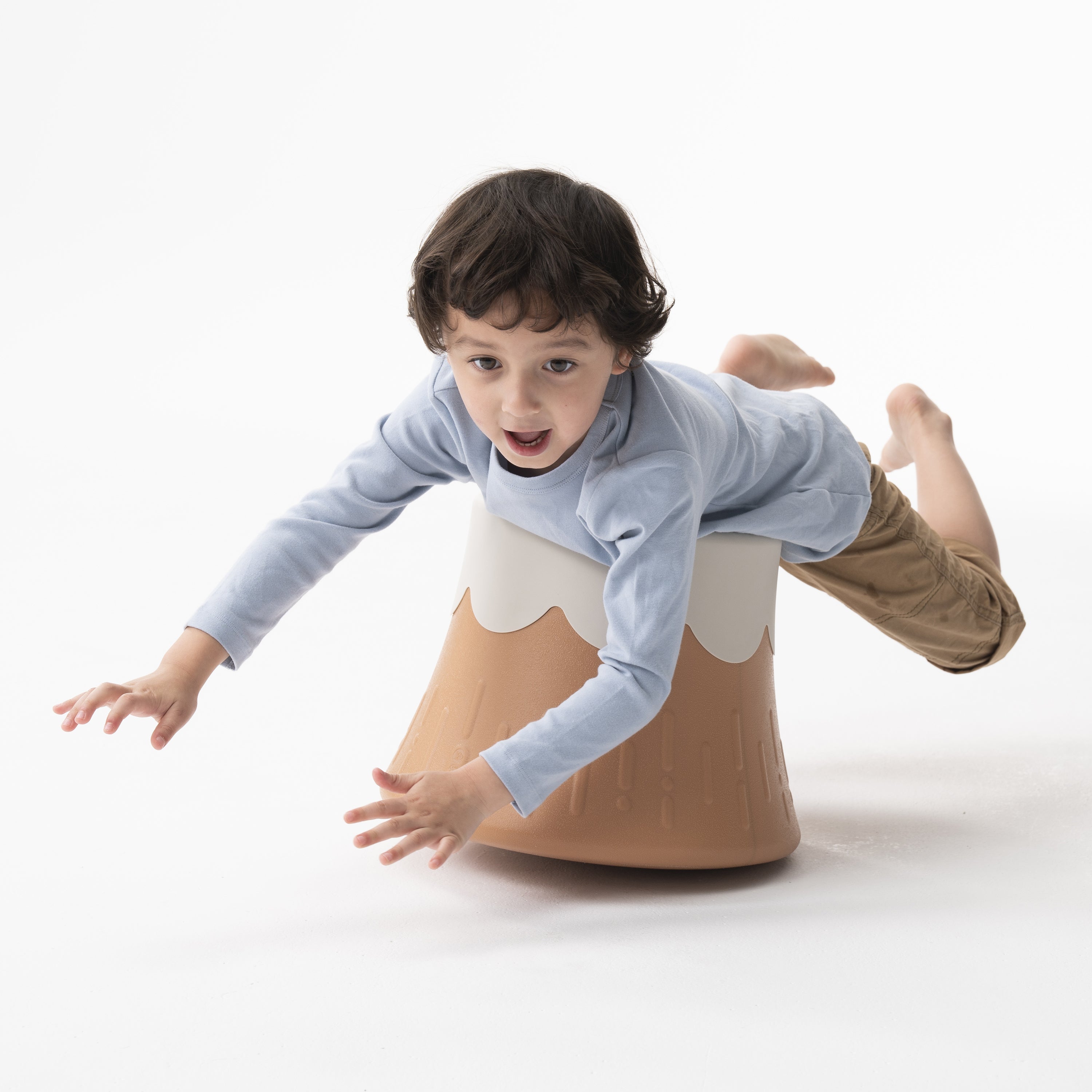 Child balancing on volcano chair on white background