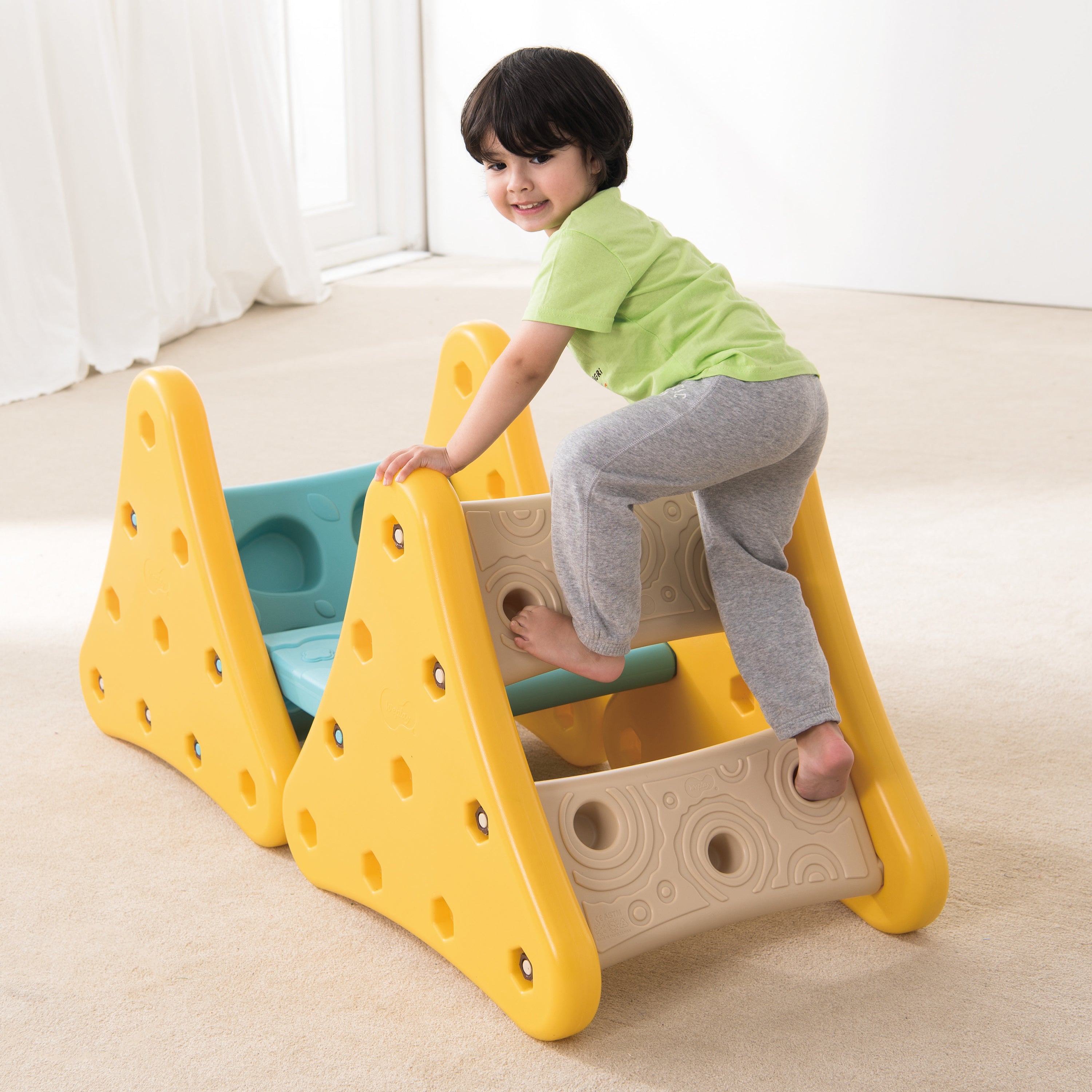 Child playing on a colorful play structure indoors