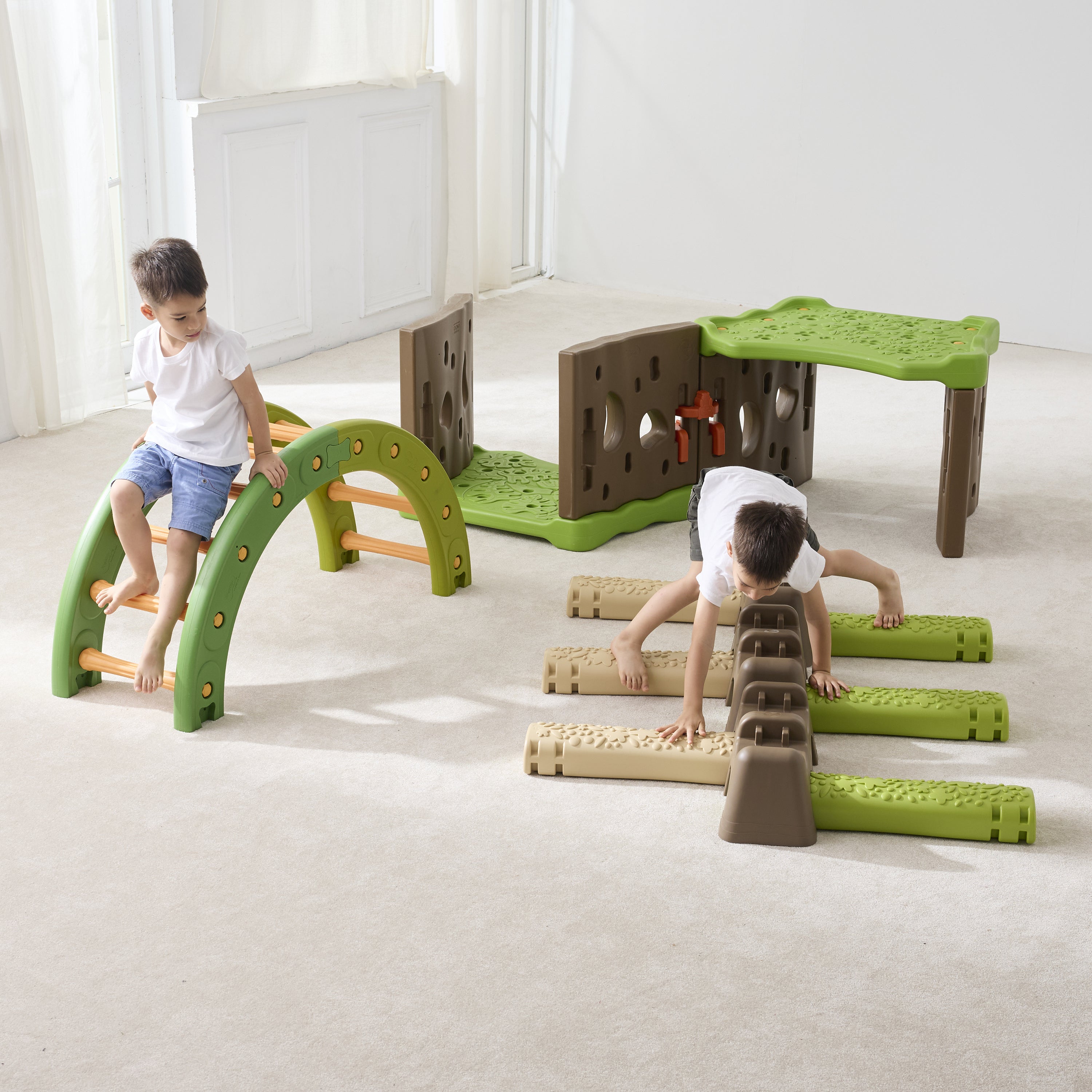 Children playing with a set of green and brown play structures on a light-colored floor.