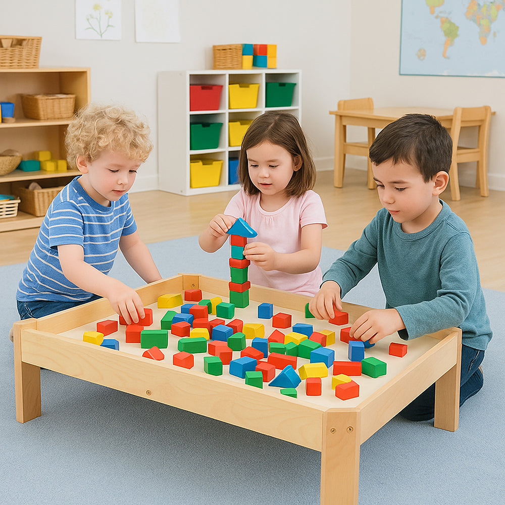 Children playing with colorful blocks at a wooden table in a classroom setting.