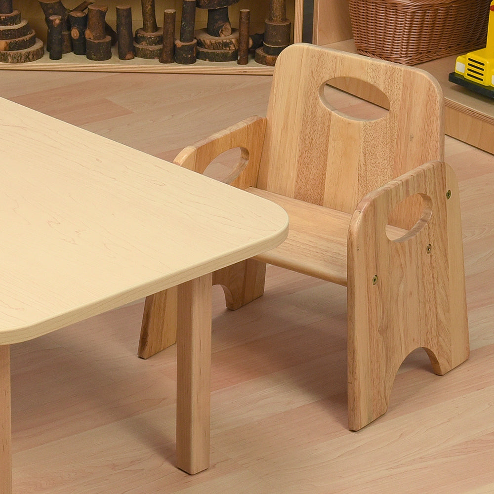 Wooden children's table and chair set on a wooden floor with toys in the background.