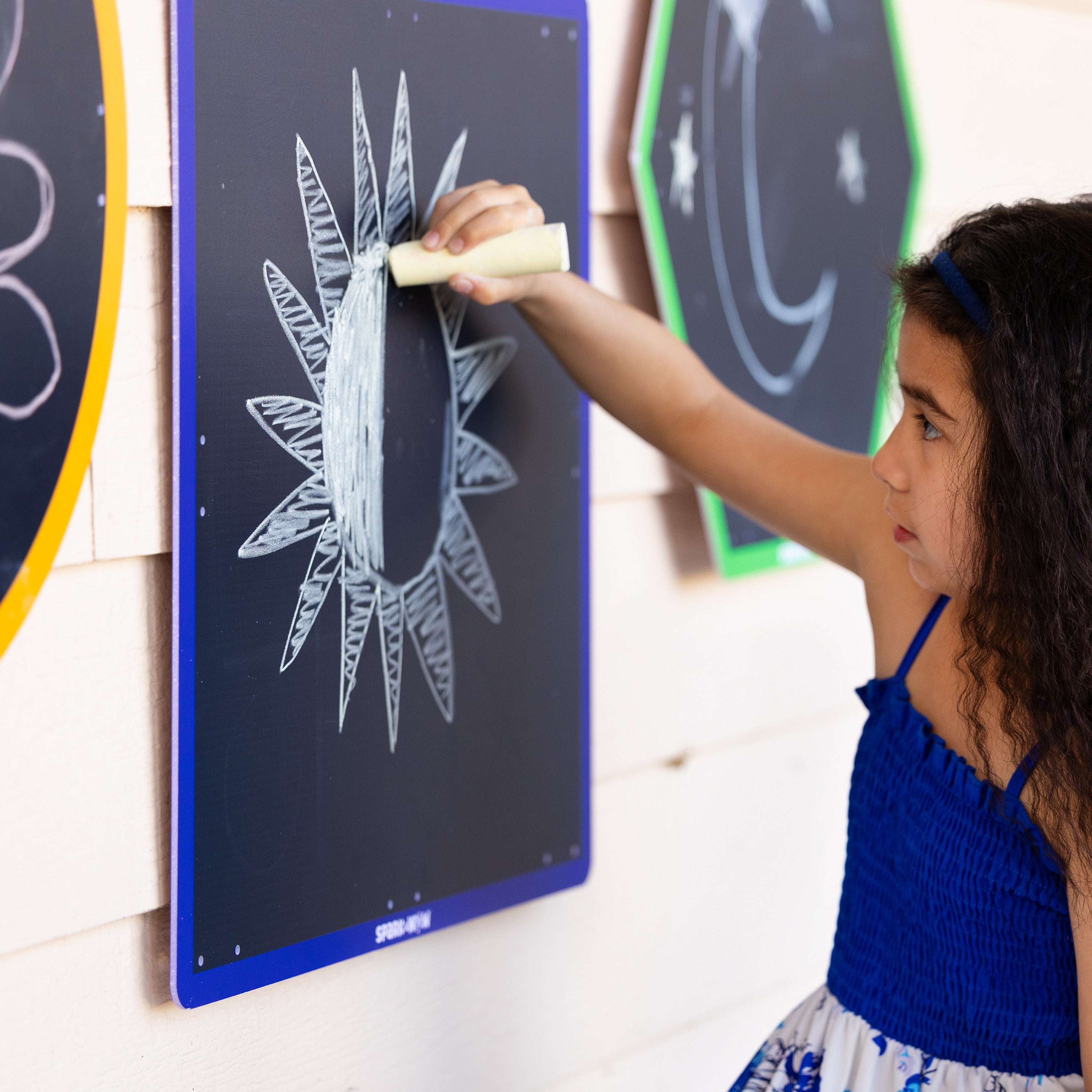 Child drawing on a blackboard with chalk