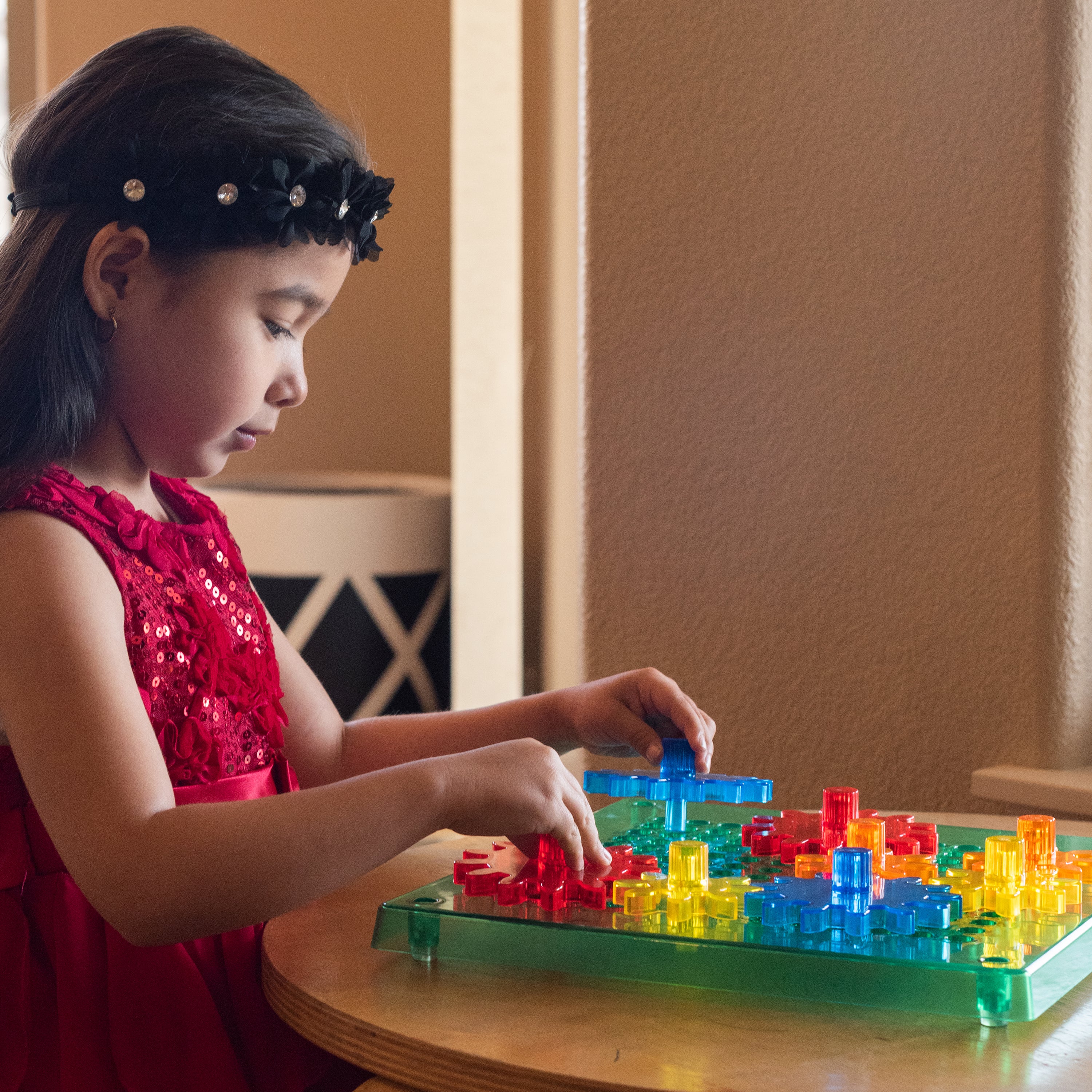 Young girl playing with colorful building blocks on a table.