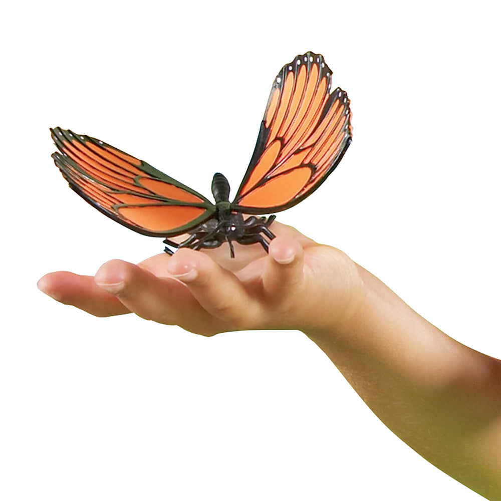 Butterfly-shaped toy on a person's hand against a white background