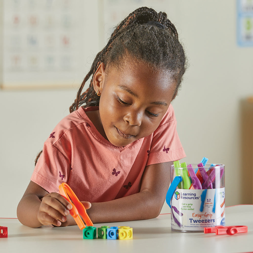 Kid Trying to Pick Up Cube with Easy Grip Tweezers