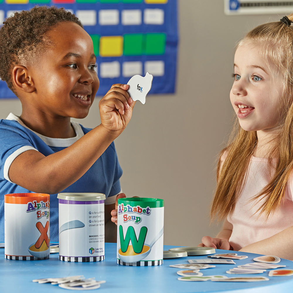 Two Kids in Classroom Engaging in Cooperative Play with Alphabet Soup Game
