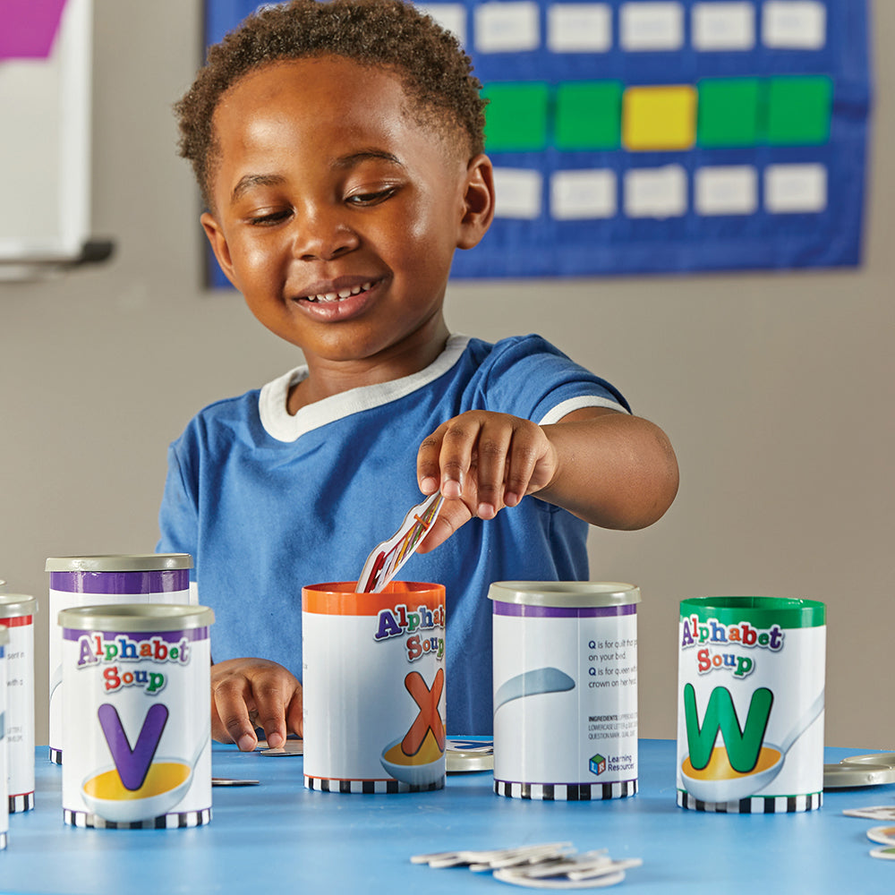 Kid in Classroom sorting Pictures in Alphabet Soup Cans