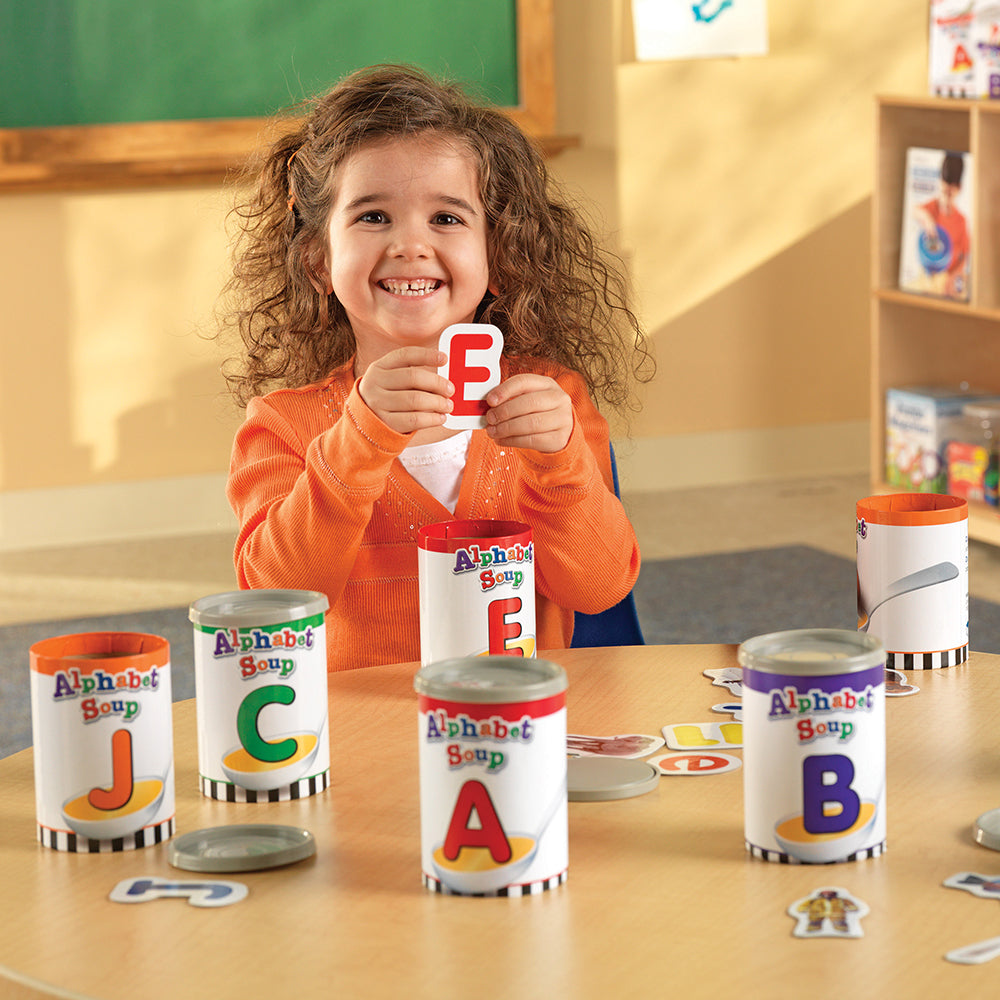 Kid in Classroom Holding Up Letter E