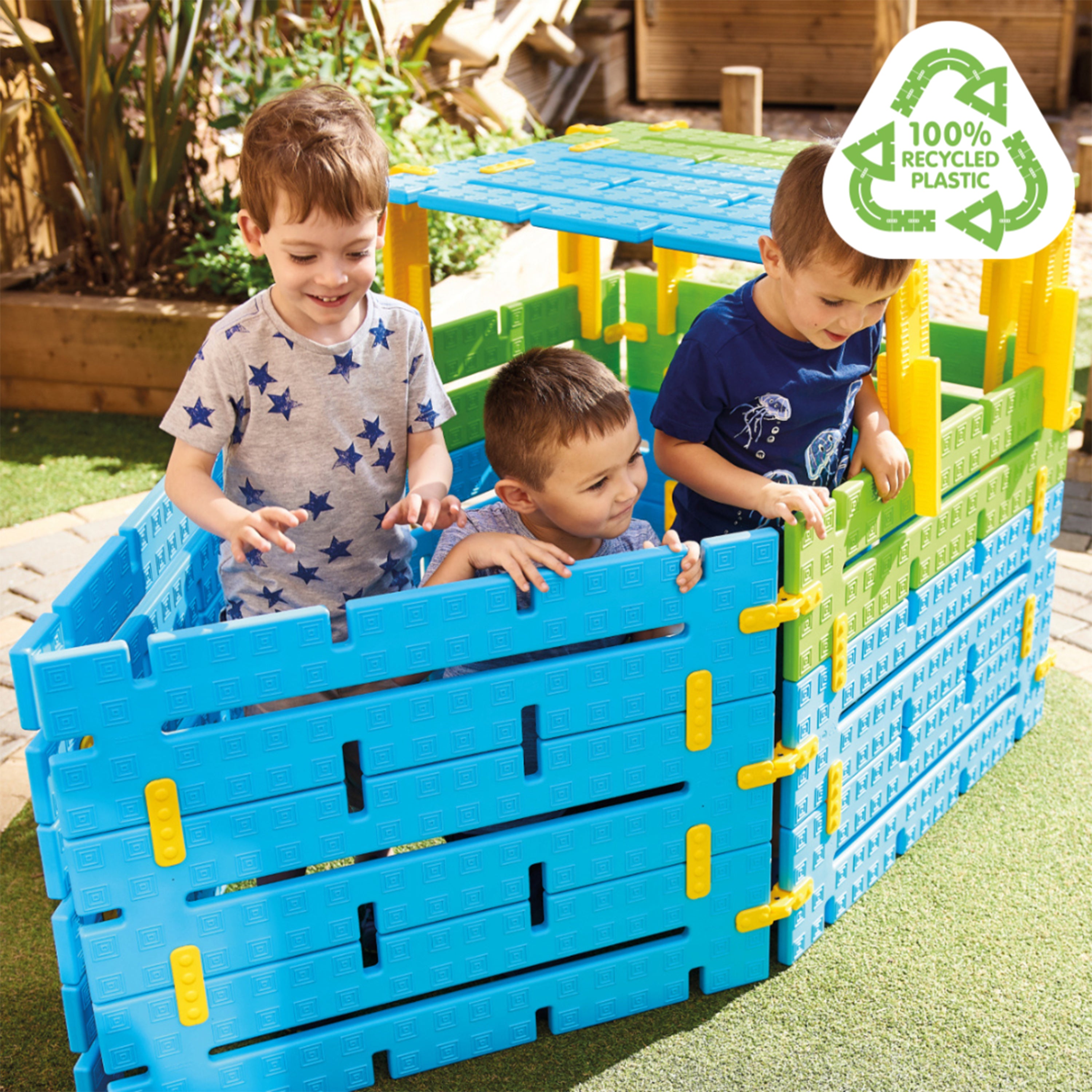 Children playing with a blue and green play structure made of recycled plastic.