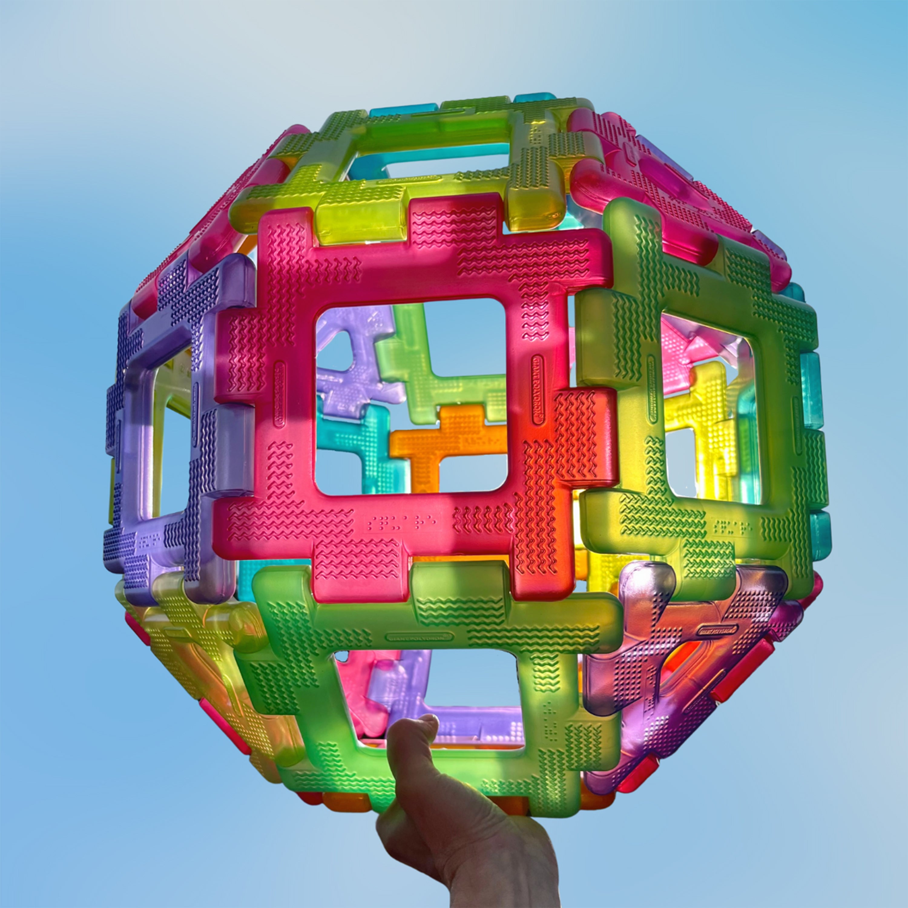Colorful magnetic building block set against a clear blue sky