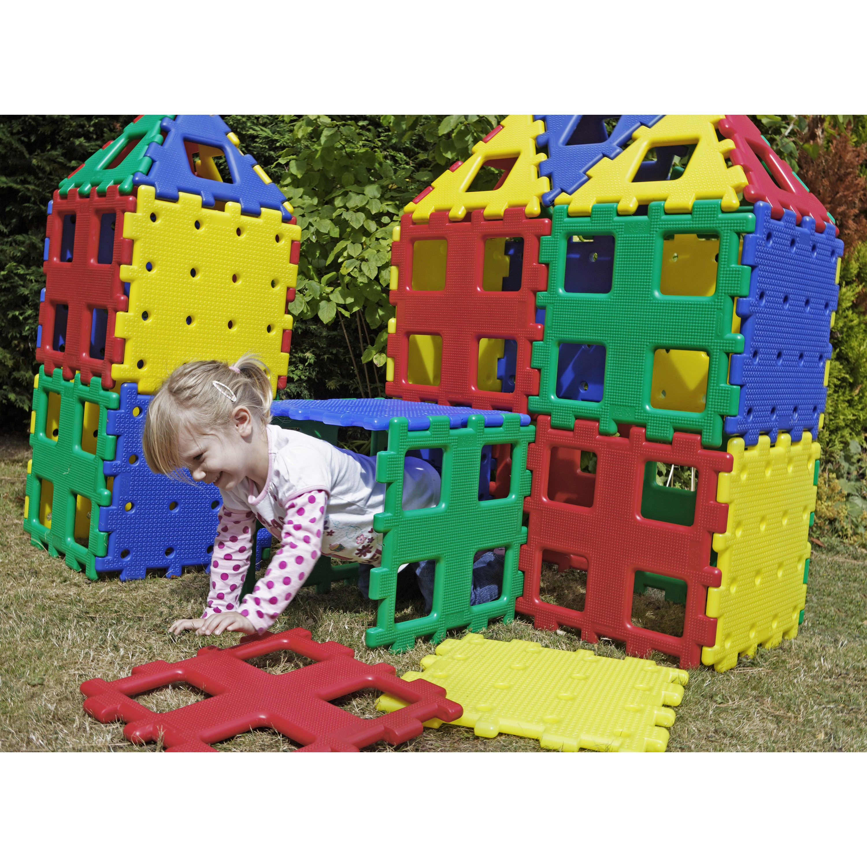 Child playing with colorful interlocking plastic tiles outdoors