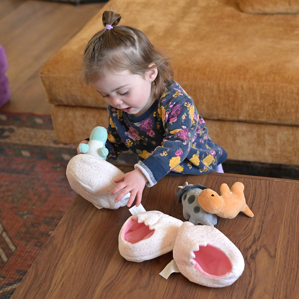 Toddler Taking Dinos Out Of Plush Eggs
