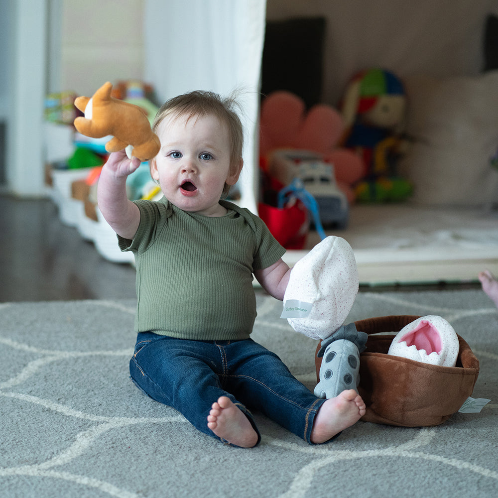 Baby Playing with Basket of Dinos