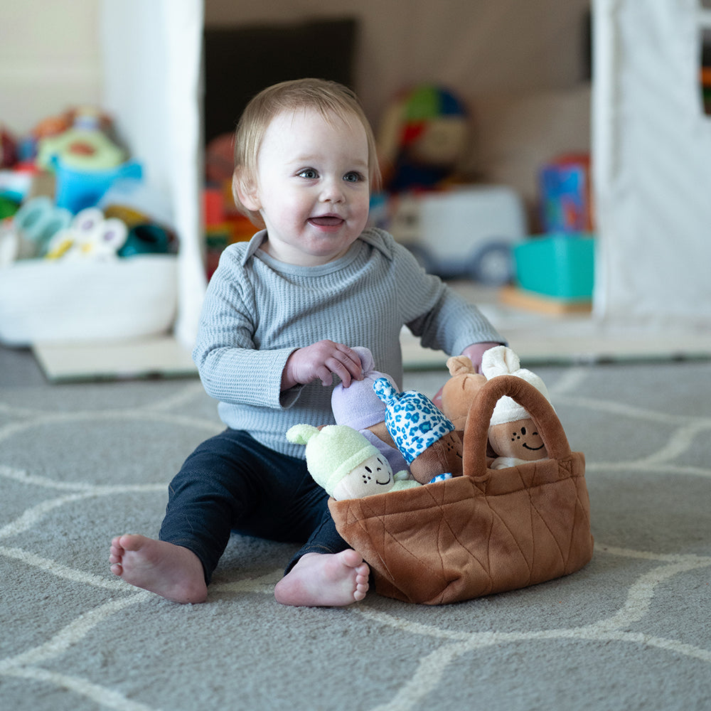 Baby Discovering Basket Full of Dolls