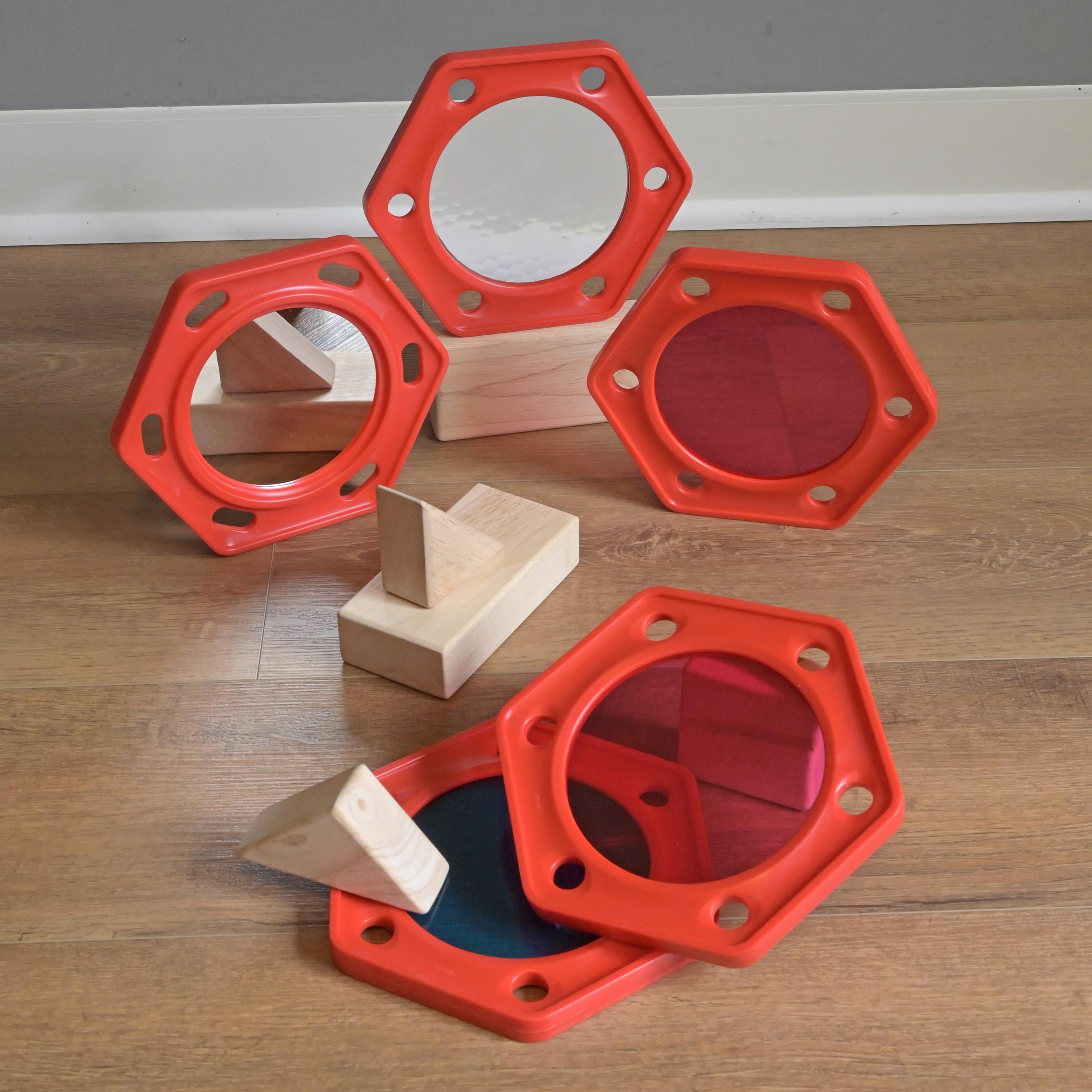 Red geometric shapes with wooden blocks on a wooden floor