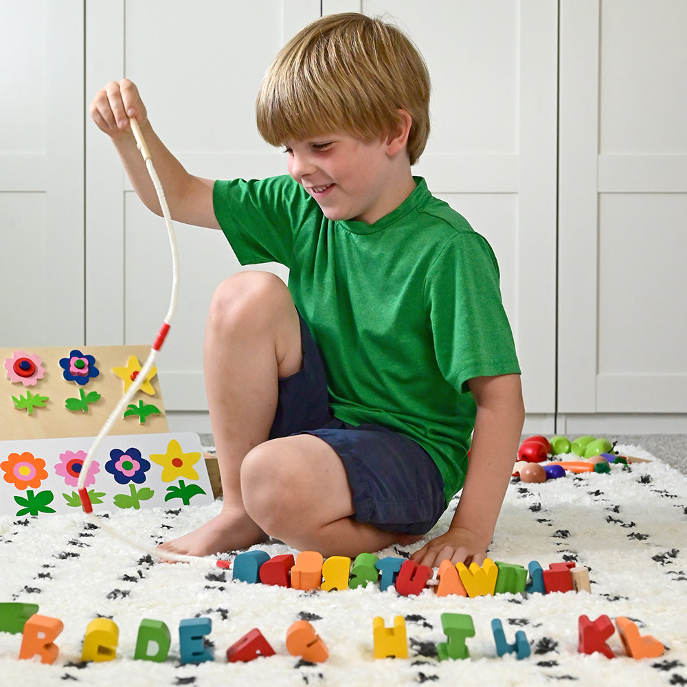 Kid Lacing Alphabet Letters in Classroom