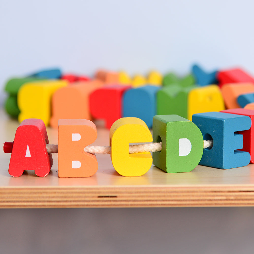Close-up of Lacing Wooden Alphabet Letters on Safety Cord