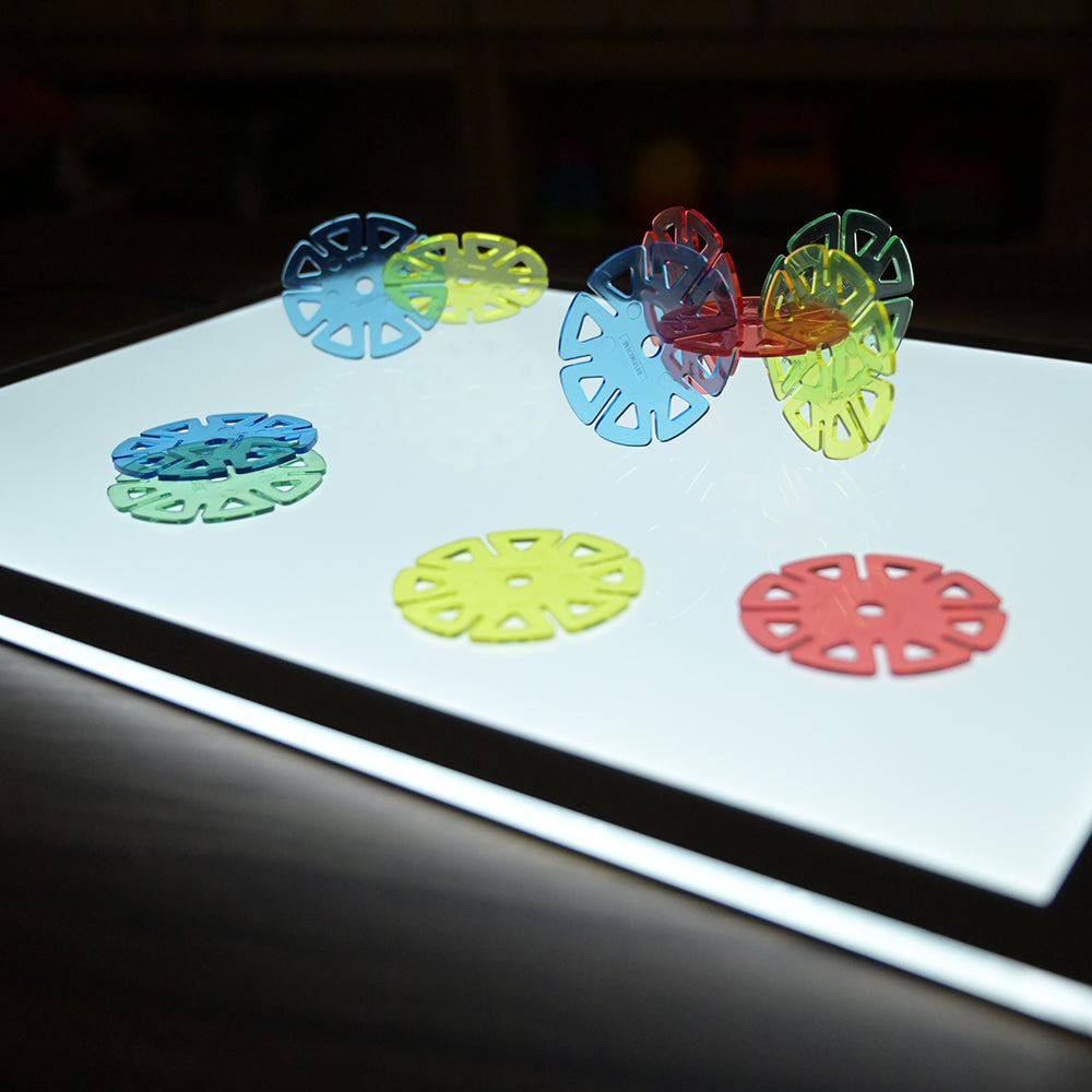 Close-up of Colorful discs on a light table with dark background