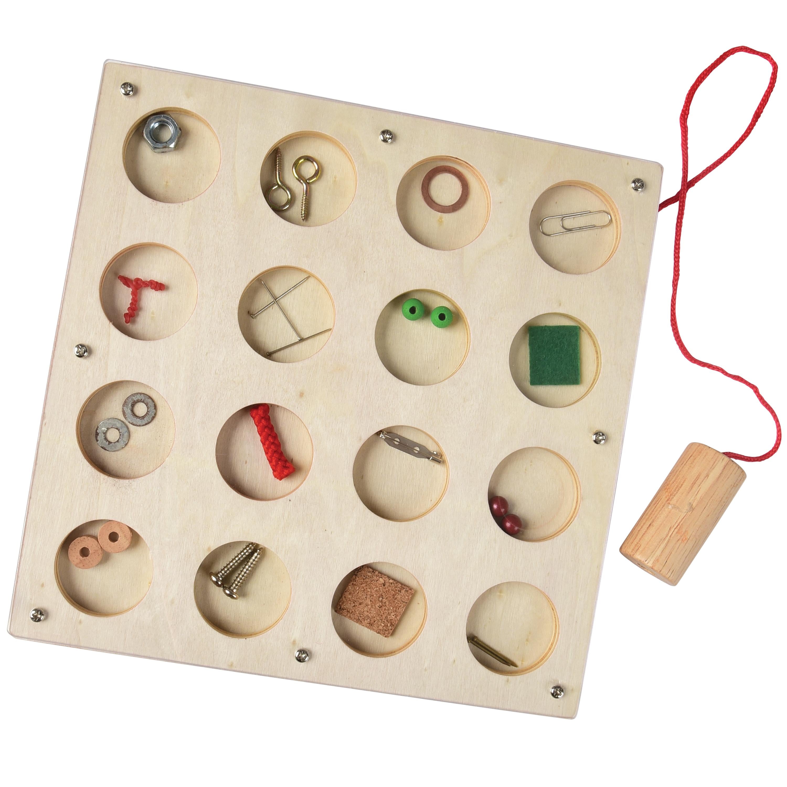 Wooden puzzle with various small objects inside circular holes on a white background