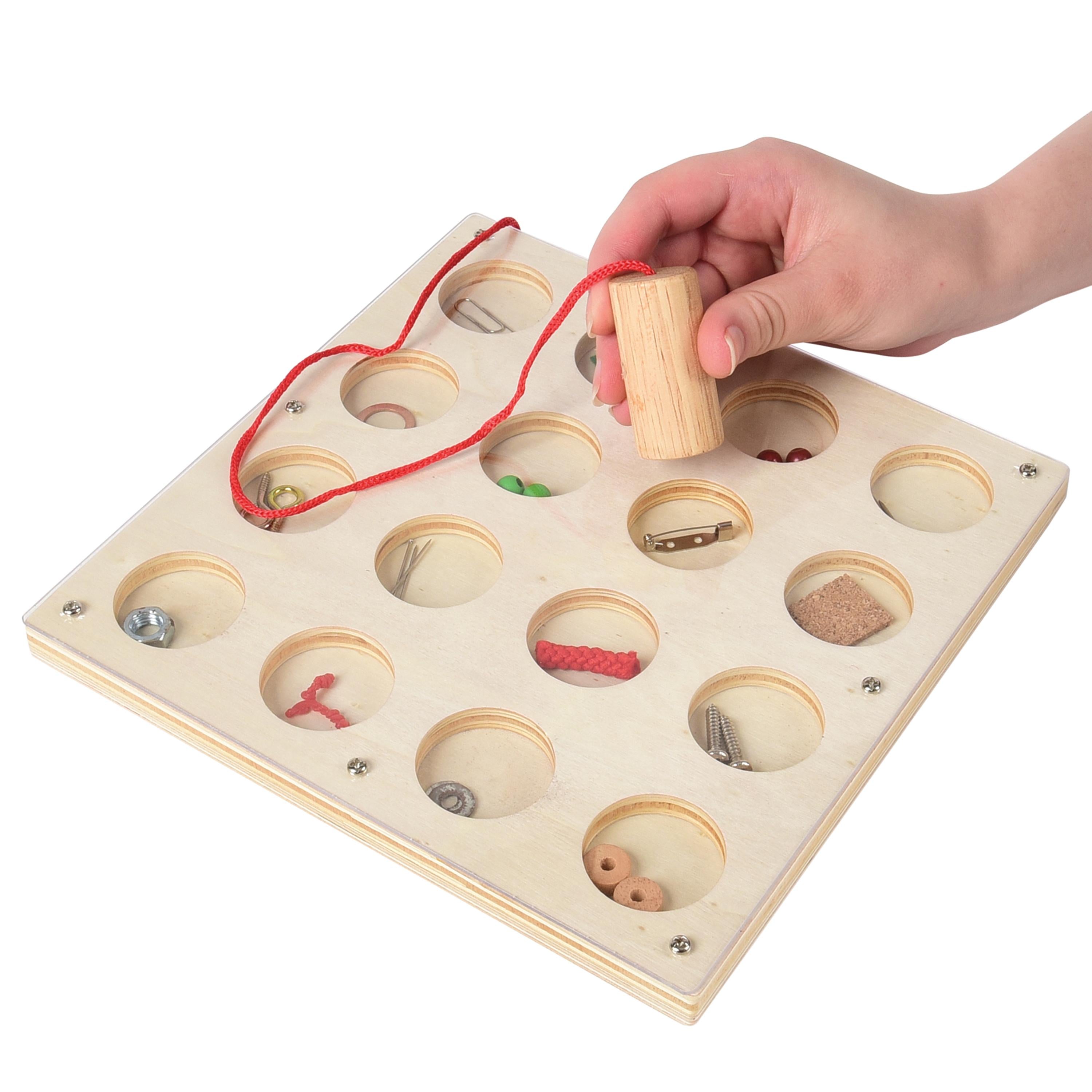 Wooden puzzle with various objects in compartments, held by a hand.