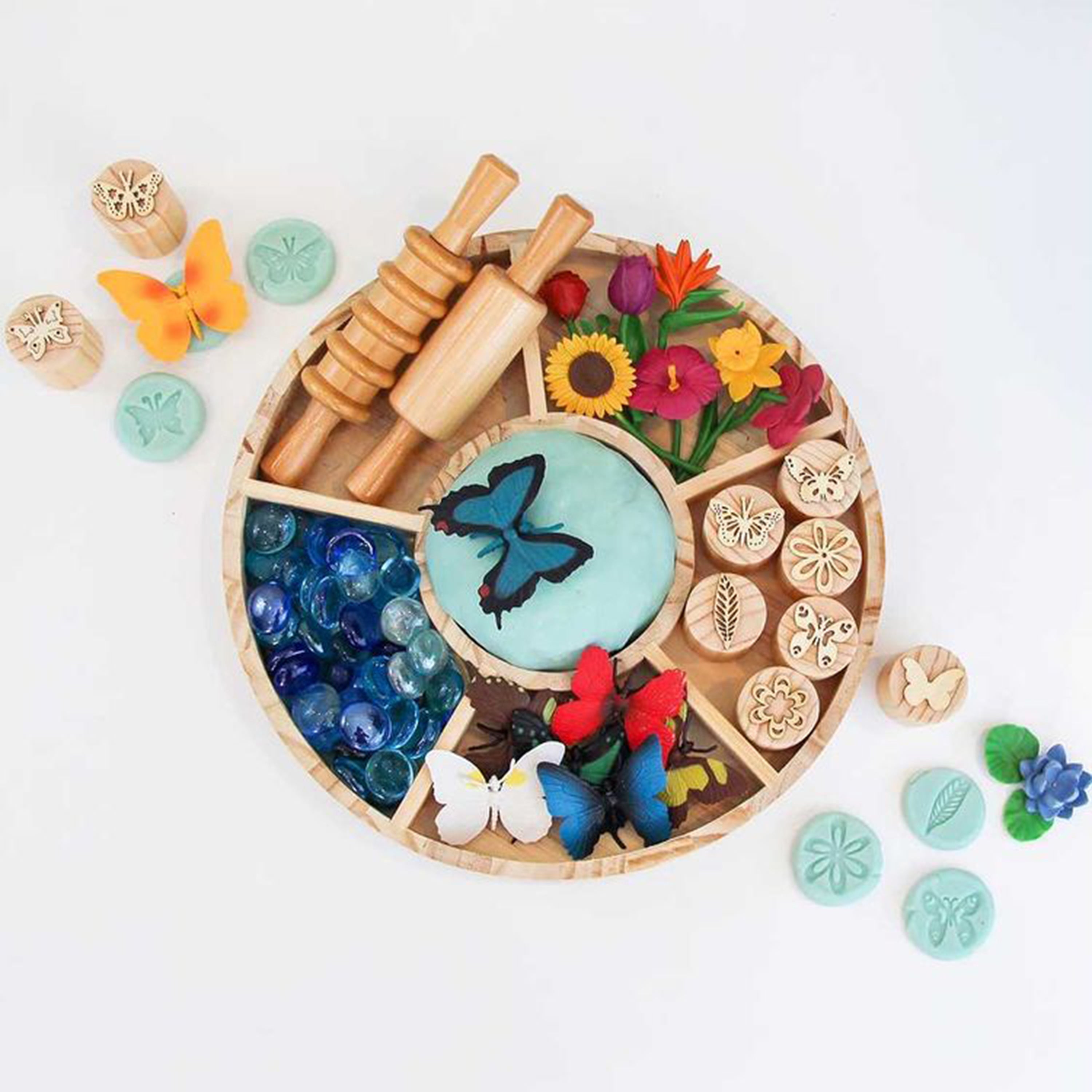 Colorful play dough set with tools and butterfly-themed items on a white background