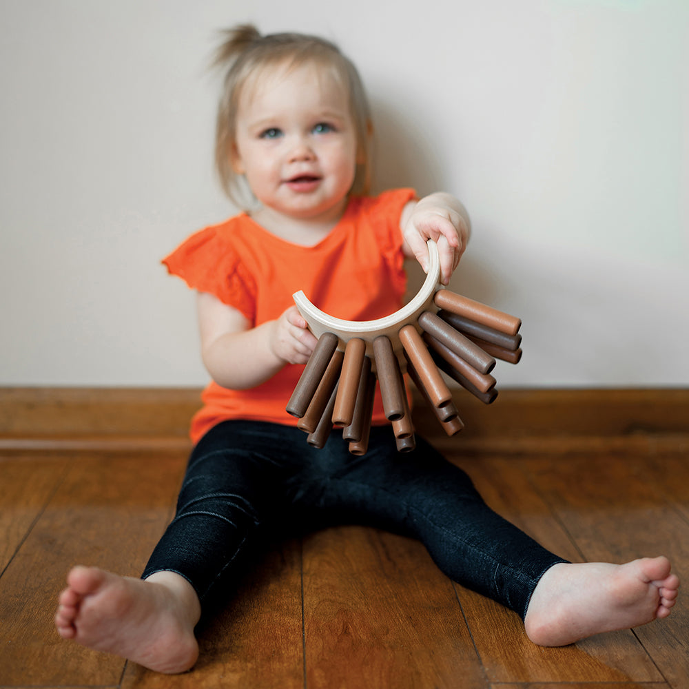Toddler Showing Eco-Friendly Wooden Jiggle Sticks
