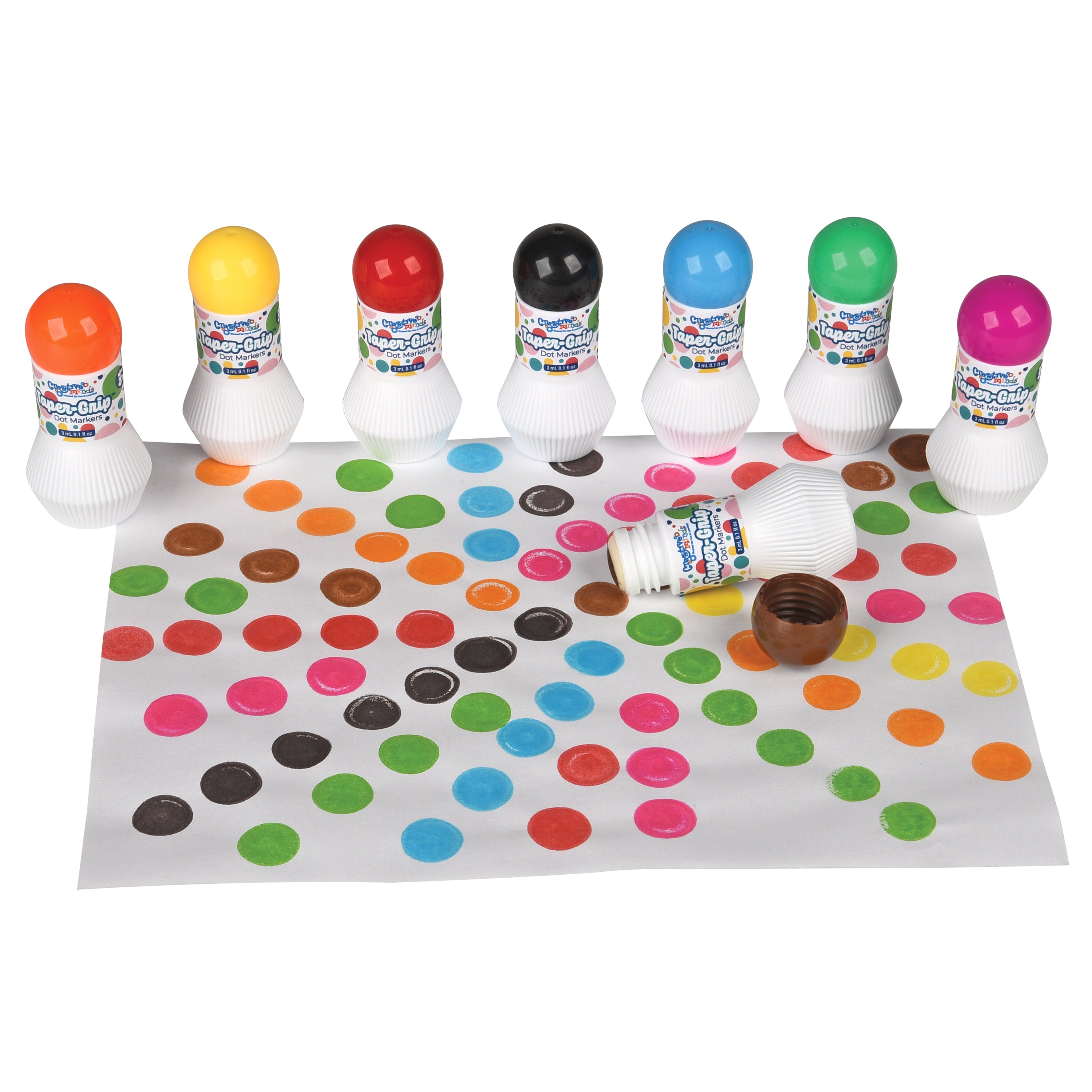 Colorful bottle caps with a polka dot mat and small container on a white background